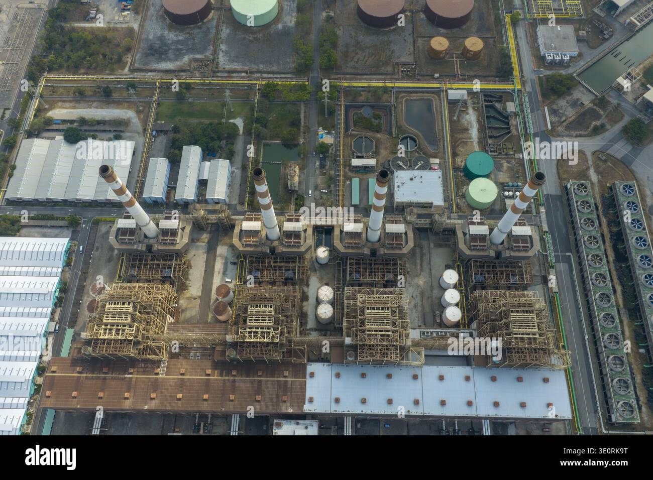 Vista aerea del paesaggio industriale, dove torreggianti camini perforano il cielo sopra strutture complesse, creando una sinfonia di forme geometriche Foto Stock