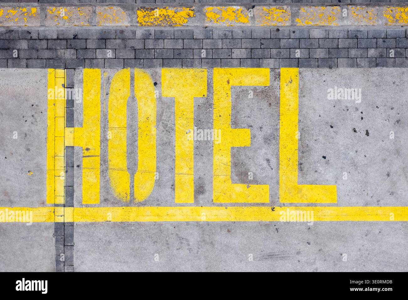 L'insegna del parcheggio dell'hotel è dipinta di giallo sulla strada, con vista dall'alto Foto Stock