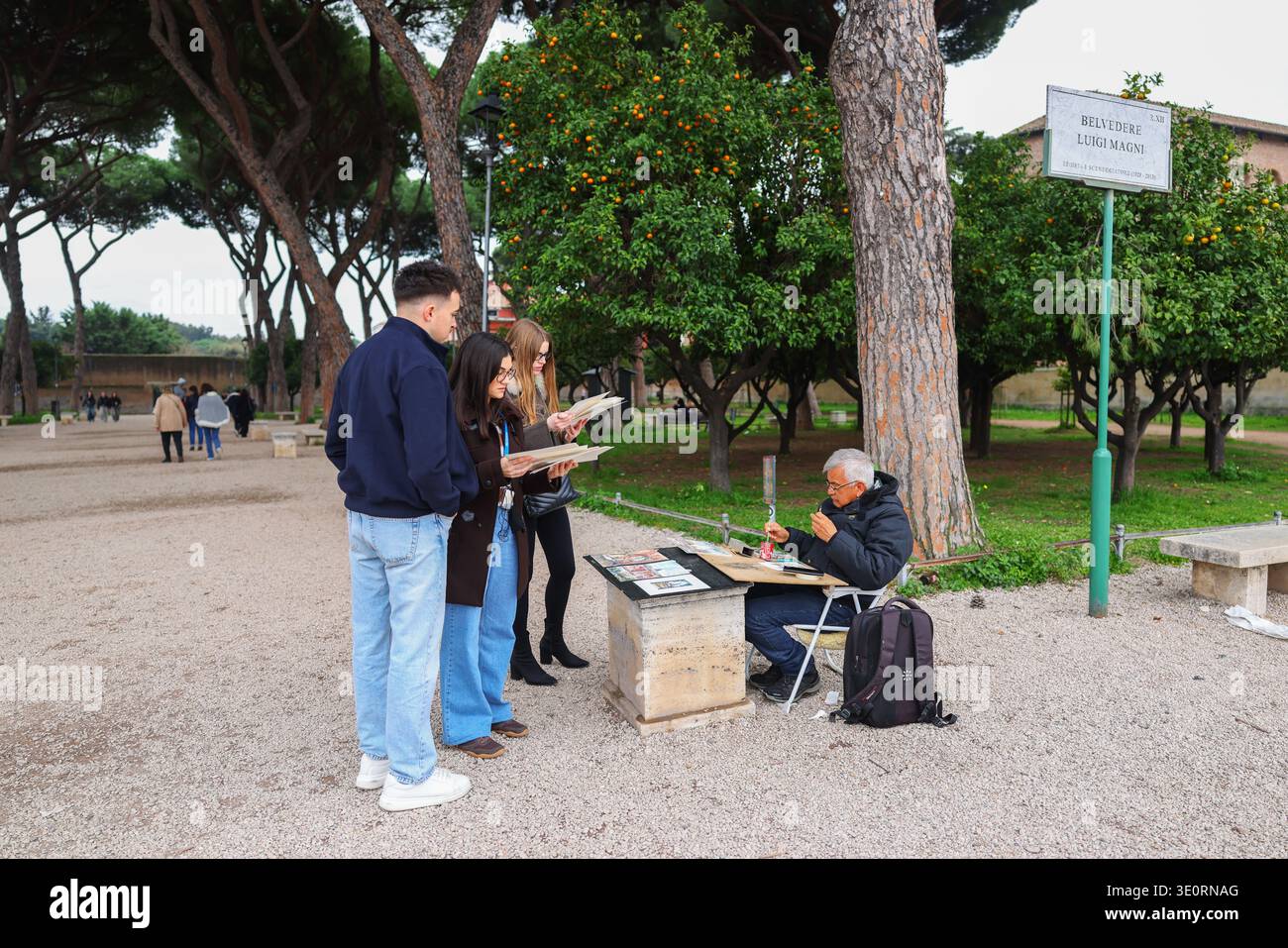 Roma, Italia – 2 marzo 2026: I turisti guardano le opere d'arte di un artista di strada nel parco di Villa Borghese vicino al belvedere Luigi Magni. Foto Stock