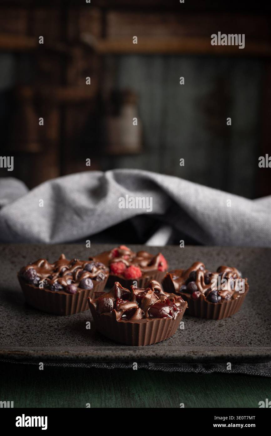 Romantici morsi di bacche di cioccolato su vassoio di pietra scura Foto Stock