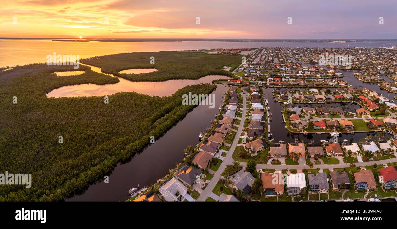 Vista aerea al tramonto delle lussuose ville sul lungomare in Florida. Sviluppo di alloggi di alta qualità con palme tropicali ed eleganti case residenziali. Foto Stock