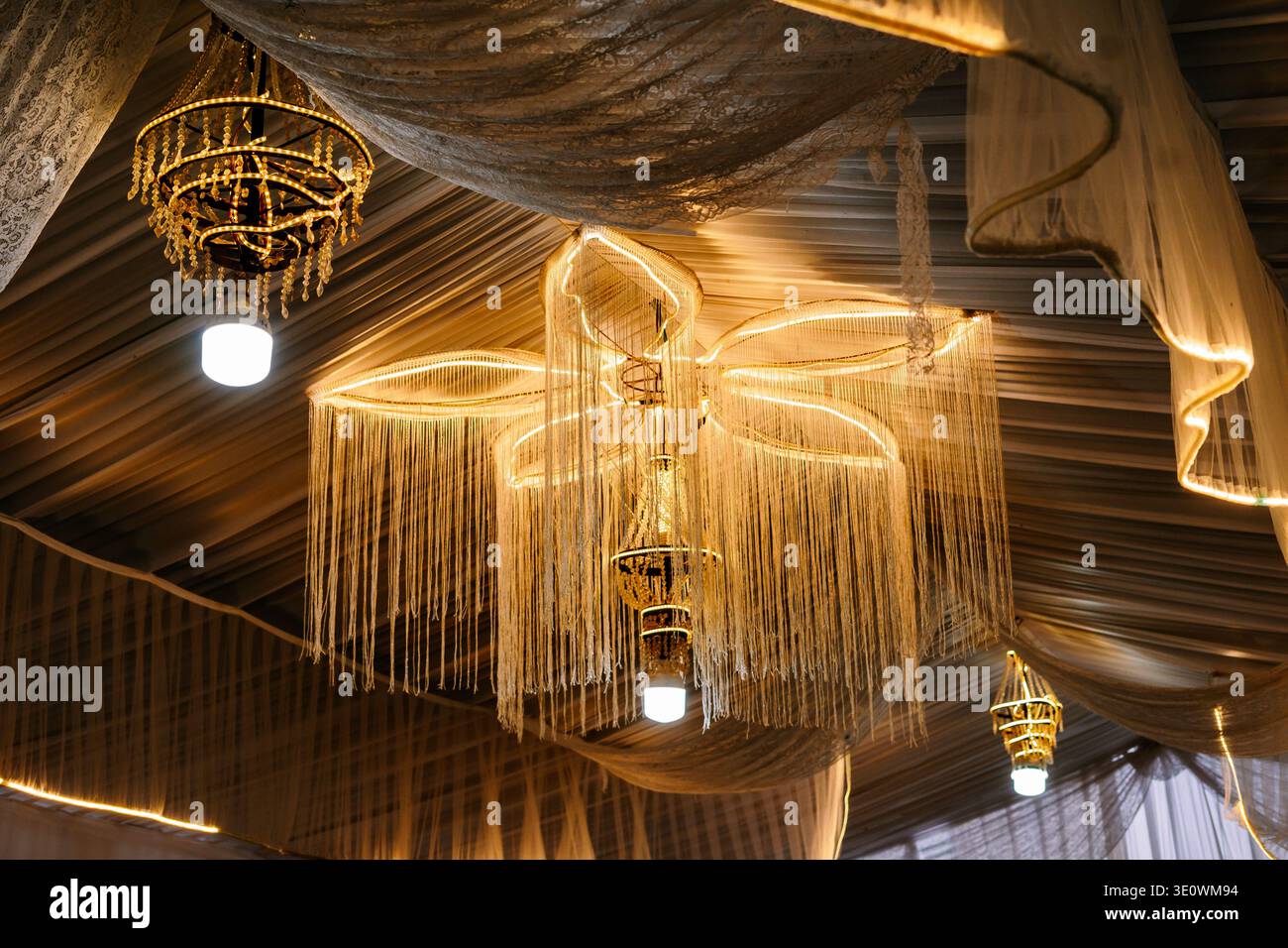 Soffitto splendidamente decorato con intricati lampadari e tendaggi in tessuto morbidi ed eleganti che creano un'atmosfera festosa e invitante per Foto Stock