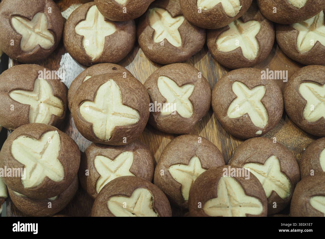 Biscotti al forno con disegno a croce su vassoio di legno Foto Stock