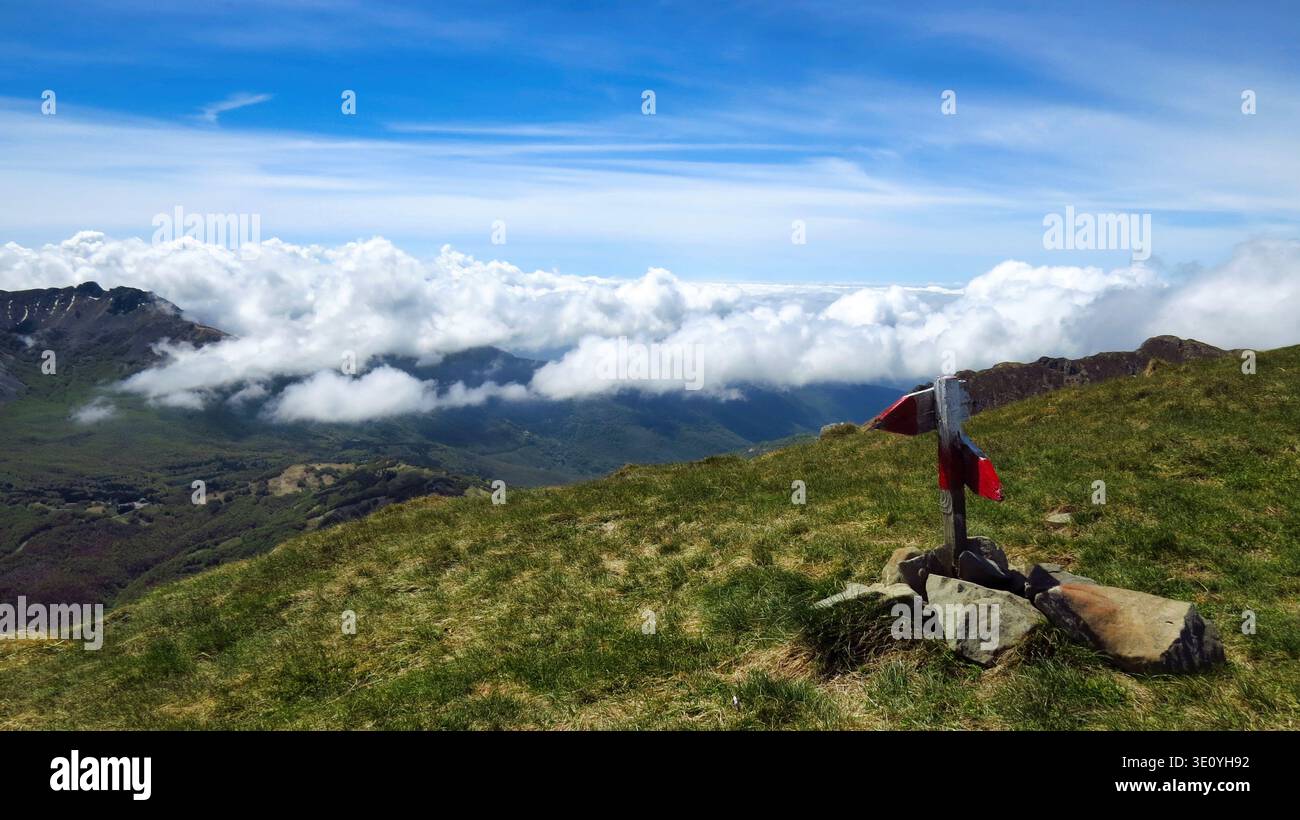 Segnavia della cima del Monte Casarola che si affaccia sulle nuvole. Una scena d'alta quota dalla vetta del Monte Casarola nell'Appennino Italiano. Foto Stock