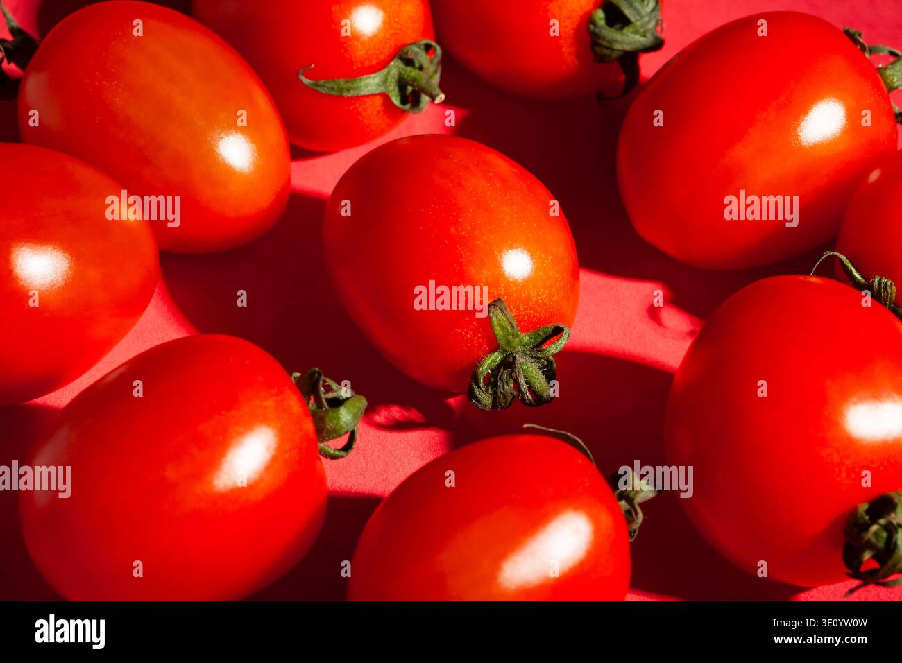 pomodoro ciliegia su sfondo rosso Foto Stock
