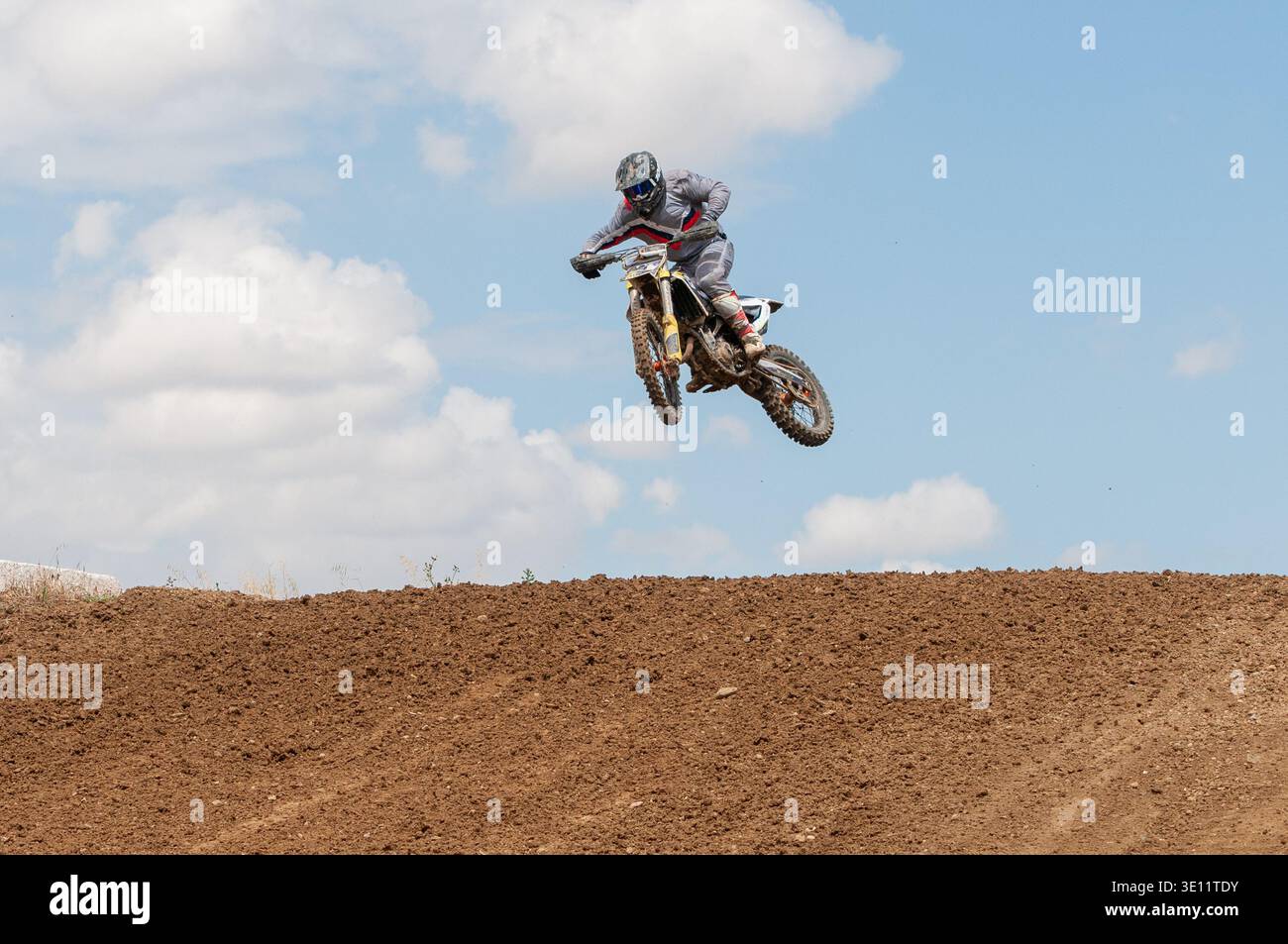 Atleta non riconosciuto che guida una moto sportiva salta in aria in una gara di motocross. Velocità elevate sport estremi.potenza ed energia Foto Stock