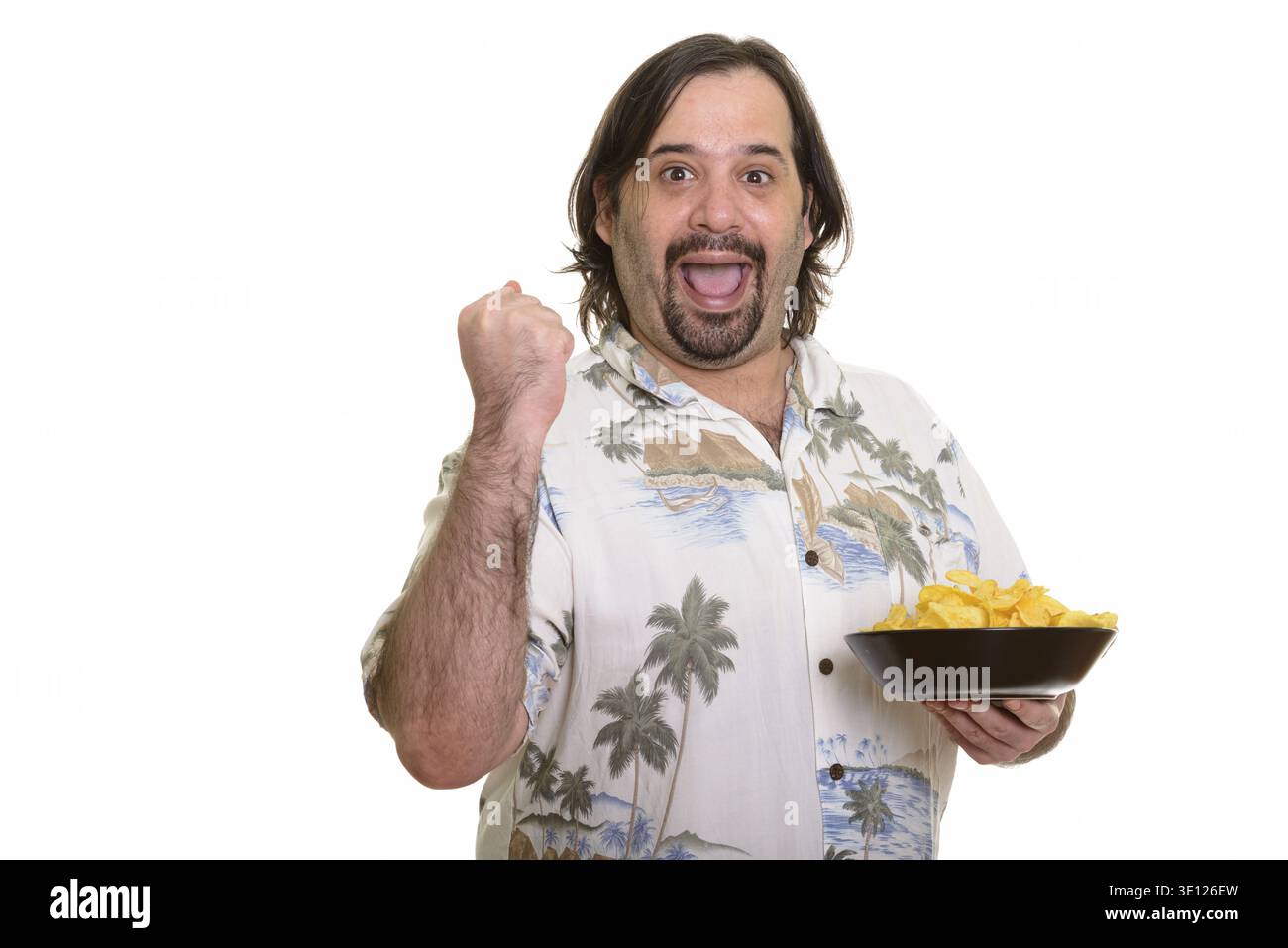 Felice uomo caucasico grasso sorridente e guardando motivato mentre teneva ciotola di patatine Foto Stock