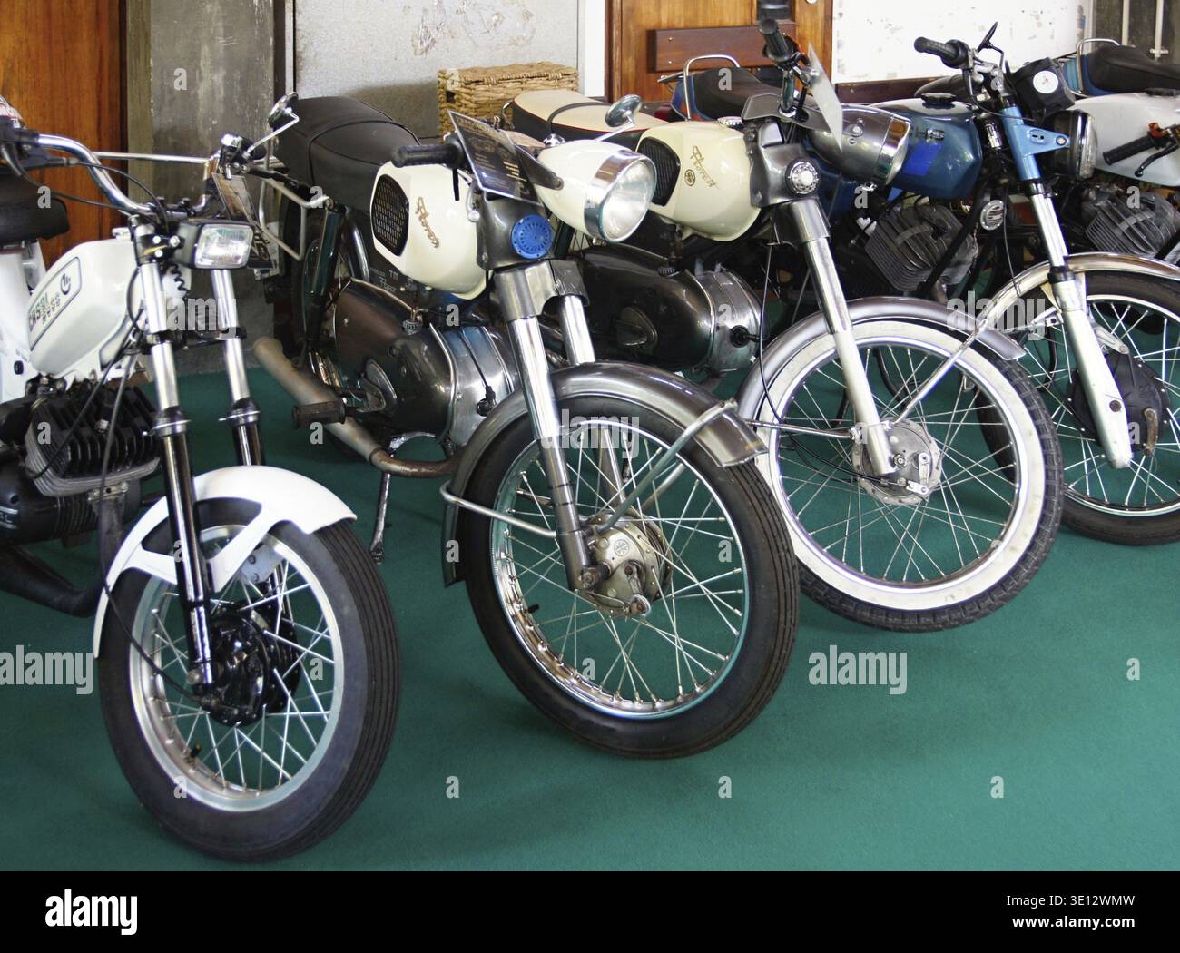 Gamma di motociclette d'epoca che espone ciclomotori e biciclette classici in una mostra museale Foto Stock