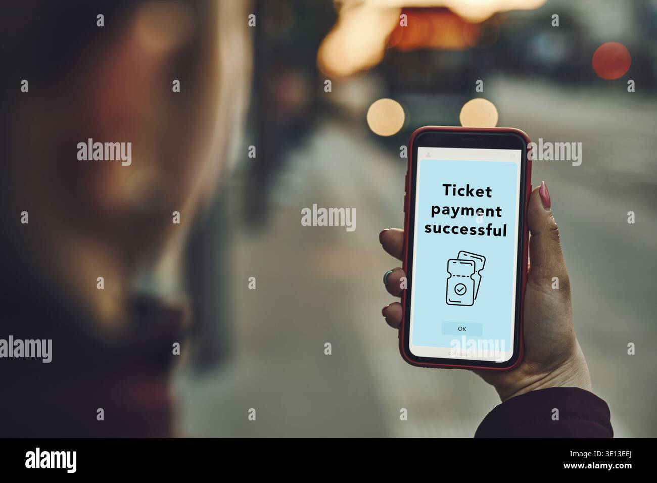 Donna che acquista il biglietto online alla fermata dell'autobus prima del giro. Persona che paga il biglietto utilizzando l'app di pagamento mobile. Utilizzo della tecnologia in movimento. Conferma dell'ordine Foto Stock