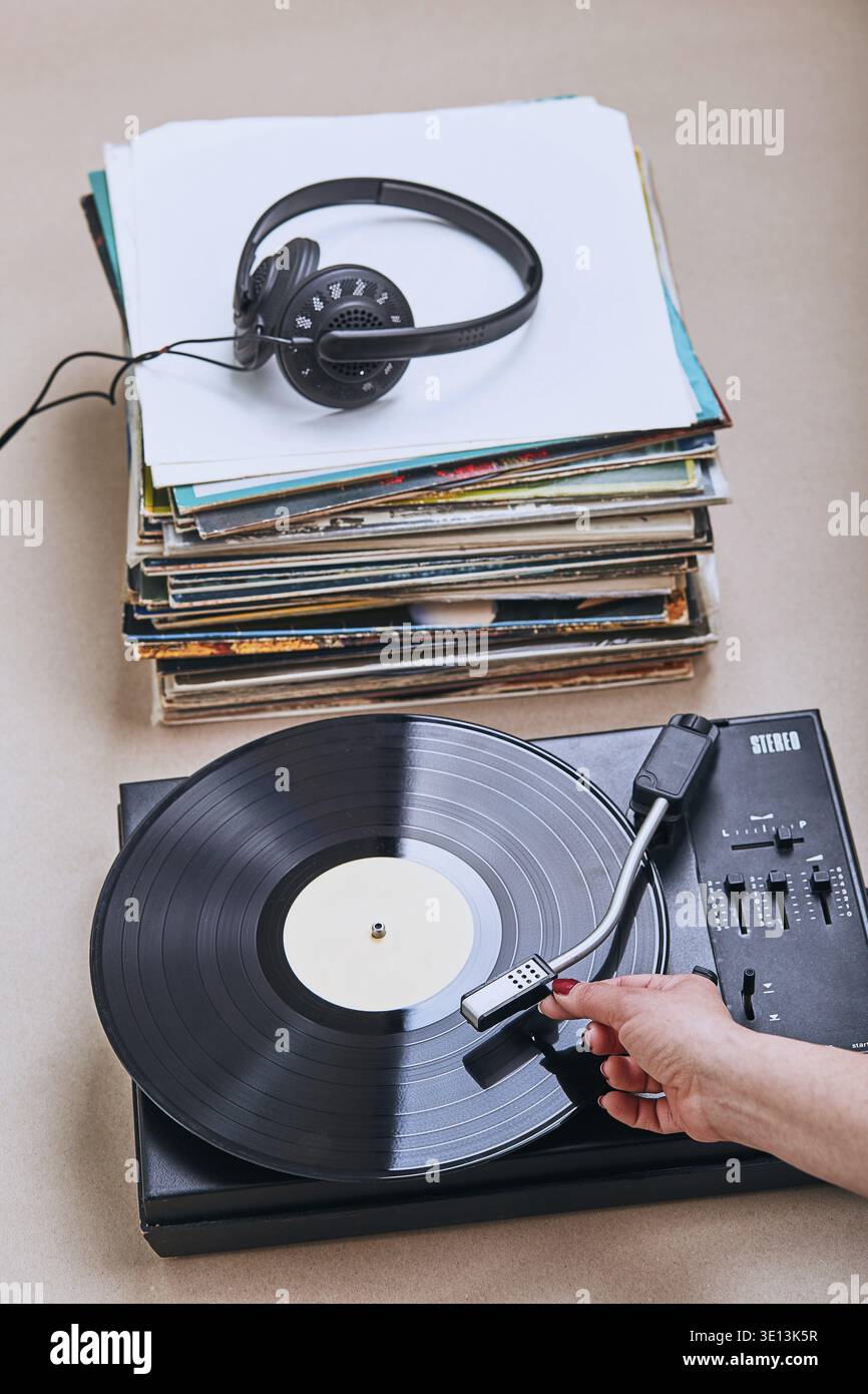 Una pila di dischi in vinile nero, un lettore giradischi in vinile e cuffie. Set stereo classico. Gente sincera, momenti reali, autentica Foto Stock