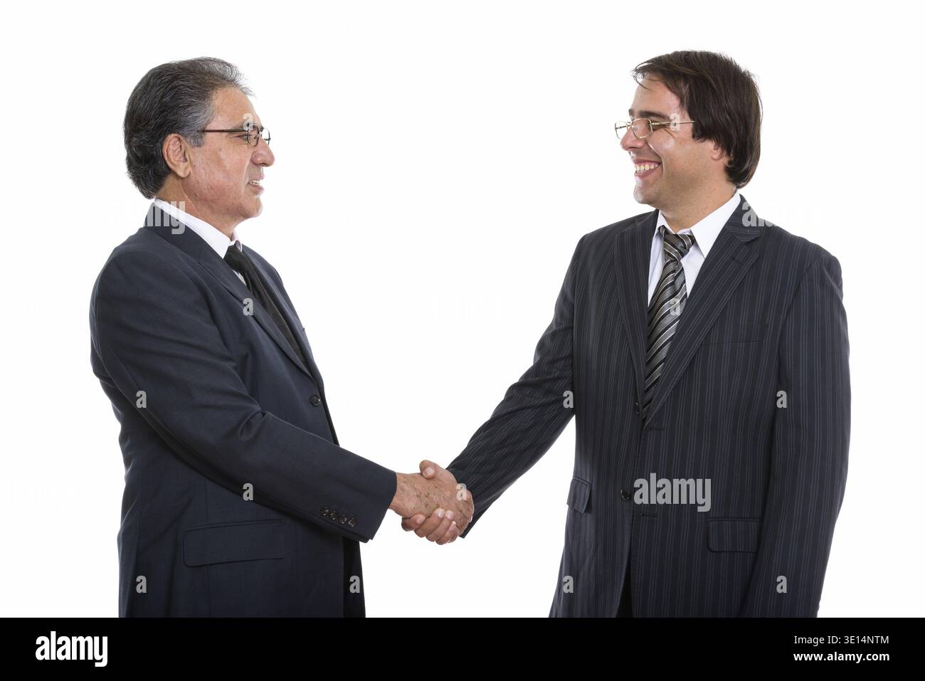 Vista di profilo di felice giovani e senior imprenditore persiano sorridente e stringono le mani Foto Stock