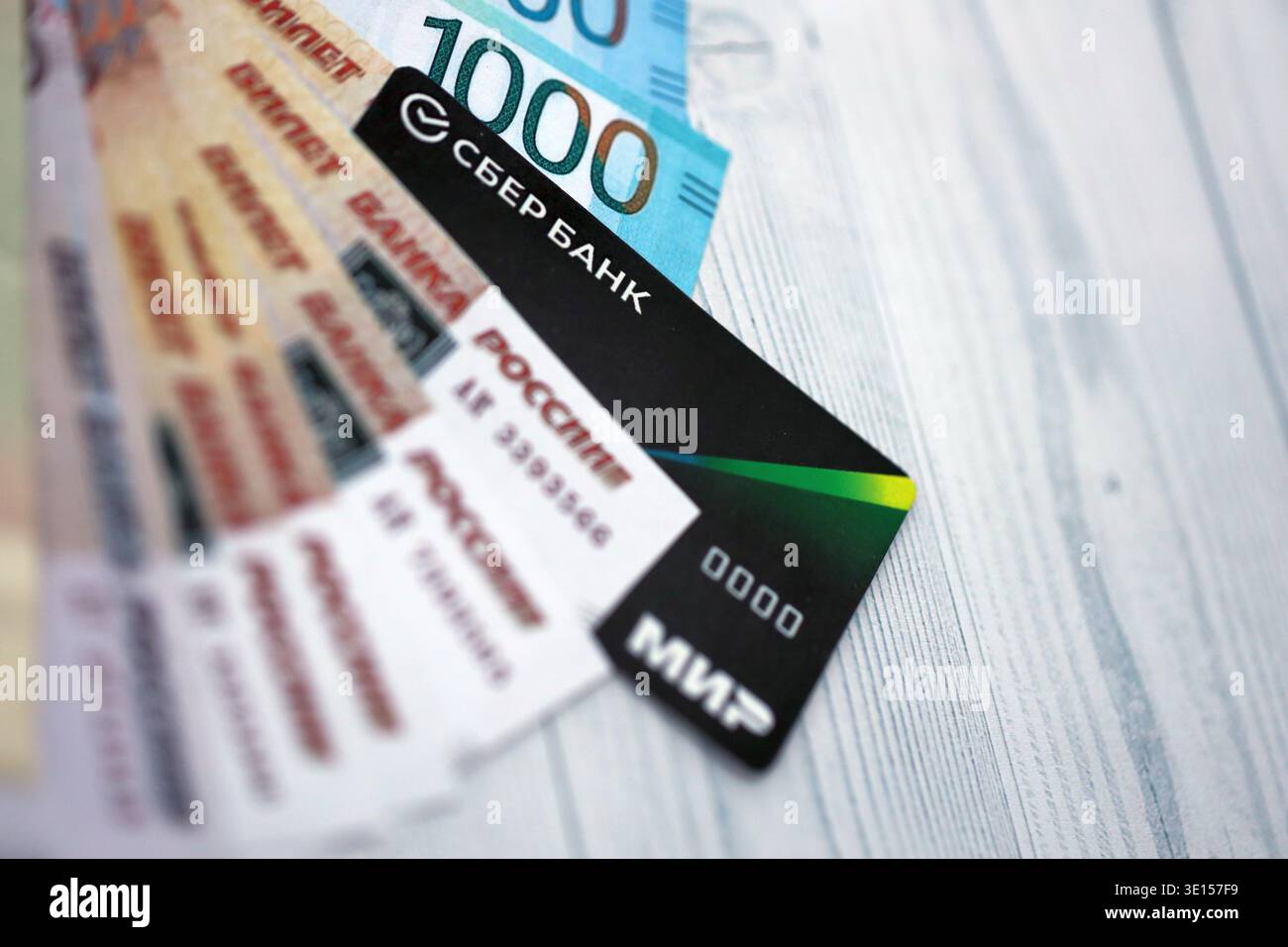 KIEV, UCRAINA - 28 GENNAIO 2026 carta Sberbank e banconote del rublo russo sul tavolo da vicino. La Sberbank è la banca più popolare in Russia Foto Stock