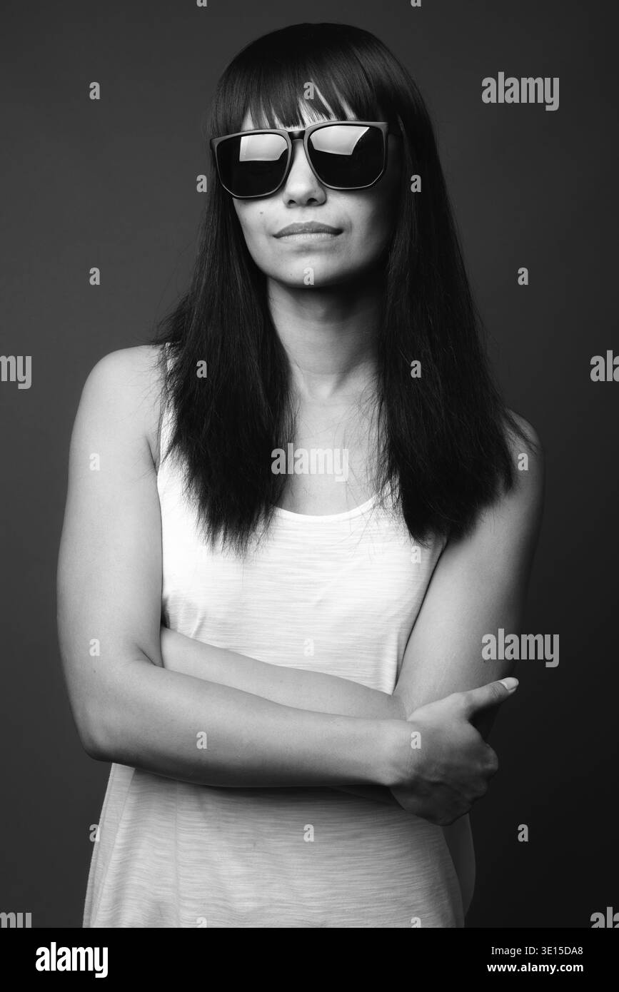 Studio shot della giovane donna asiatica contro uno sfondo grigio in bianco e nero Foto Stock