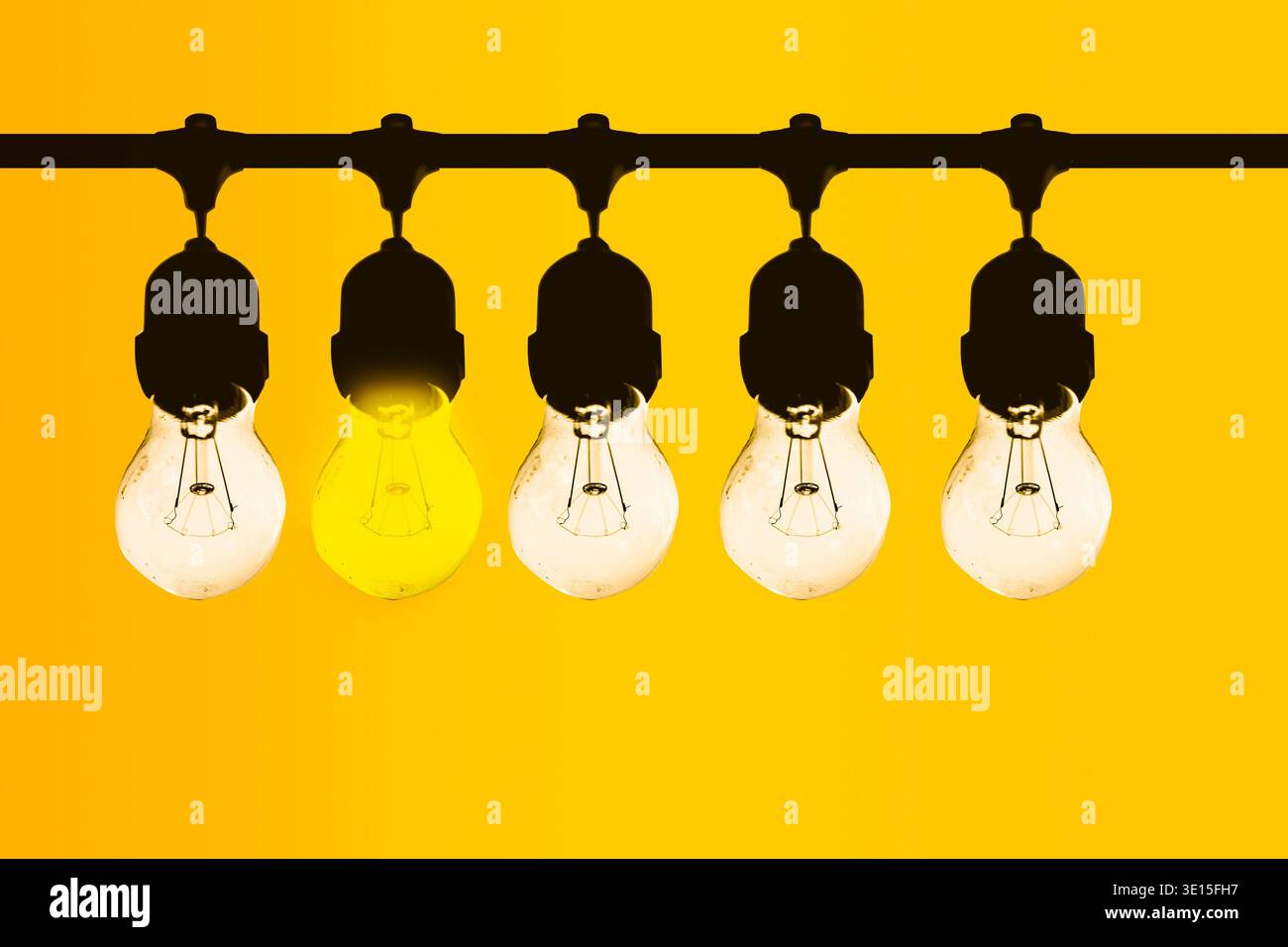 Brillante idea a risparmio energetico spicca tra le lampadine standard che rappresentano innovazione e creatività Foto Stock