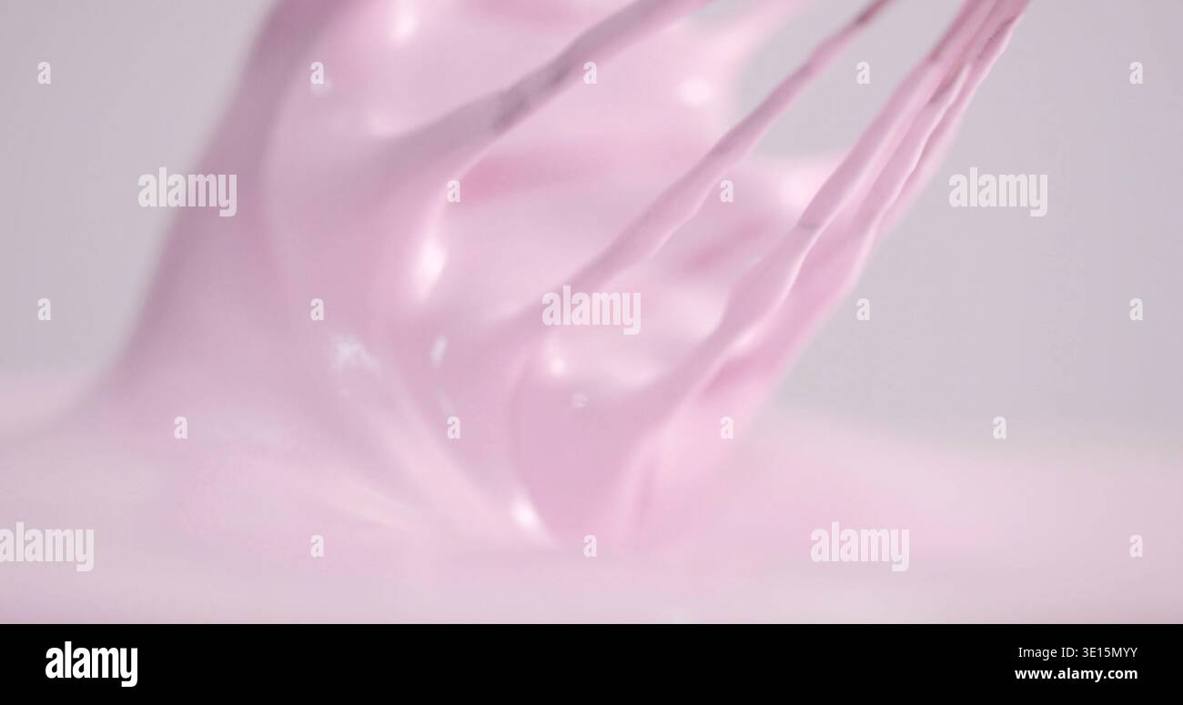 Mescolare la glassa rosa per decorare le torte in cucina durante il giorno Foto Stock