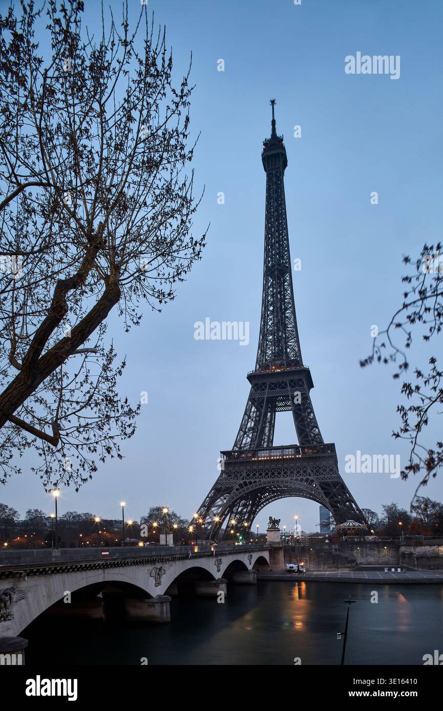 Torre Eiffel vista dal fiume sotto la luce blu della sera. Foto Stock