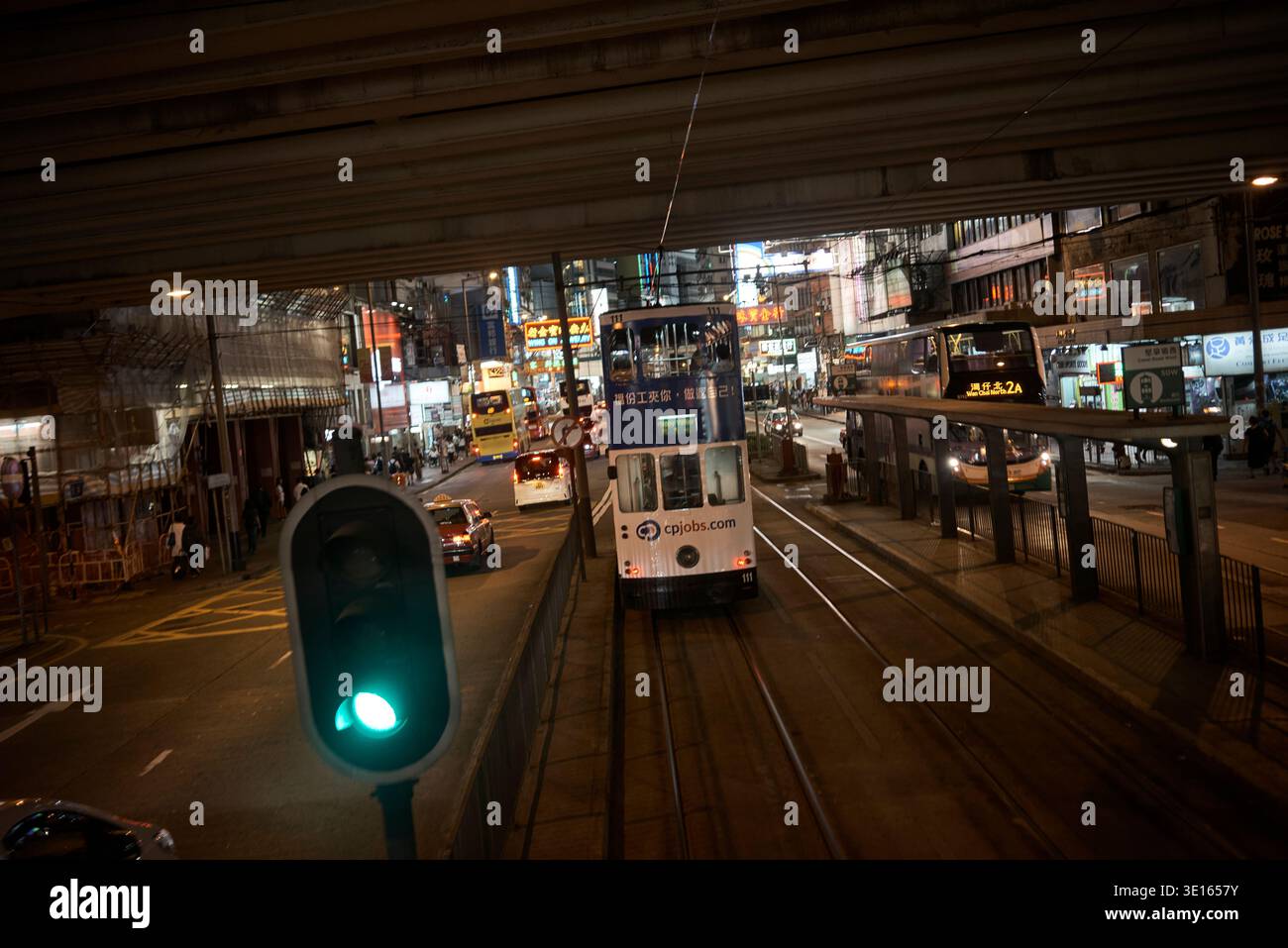 Scena notturna del tram sotto un cavalcavia urbano a Hong Kong. Foto Stock