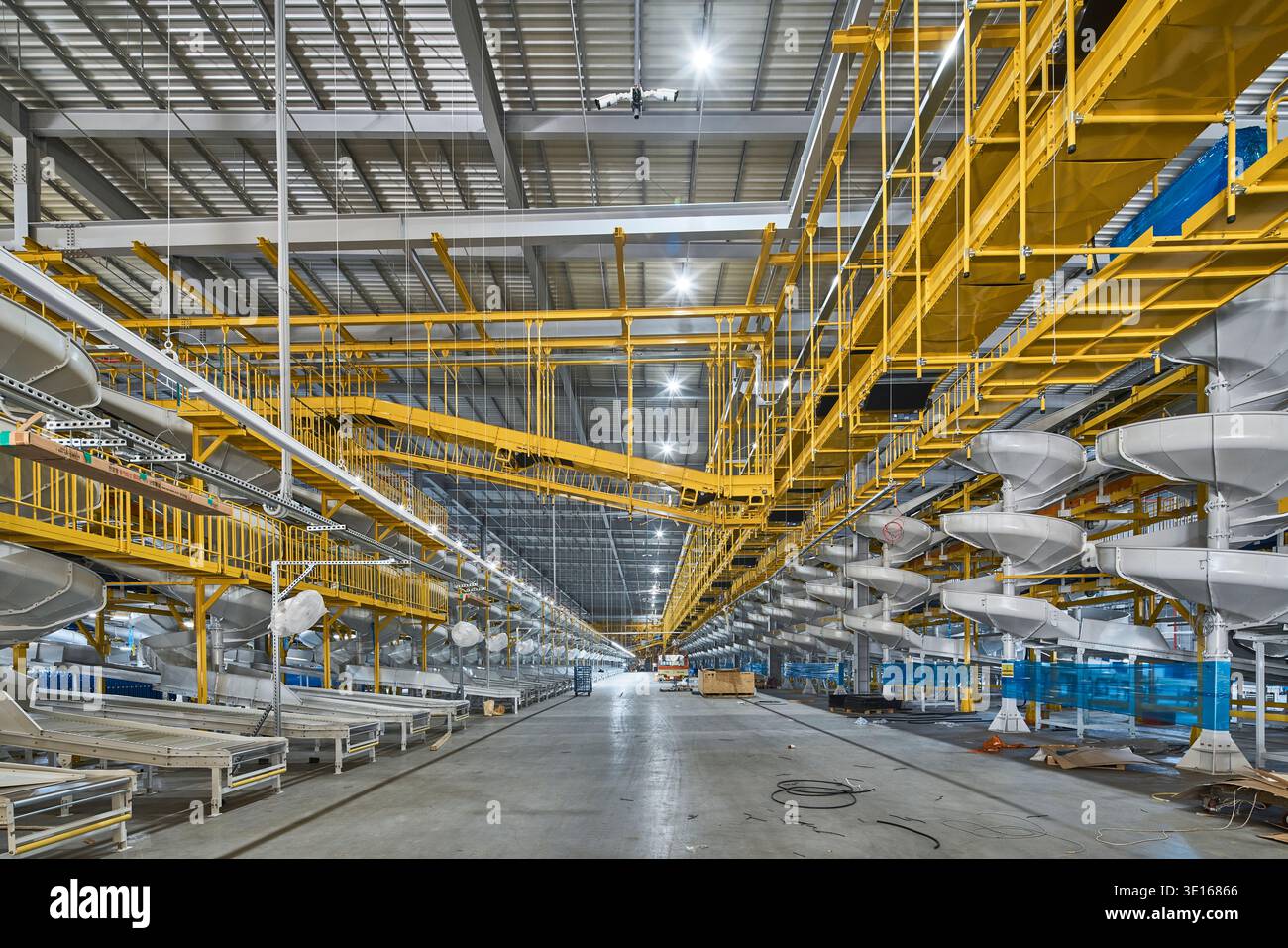 Ampio spazio logistico interno con trasportatori, passerelle e telai in acciaio multilivello. Foto Stock