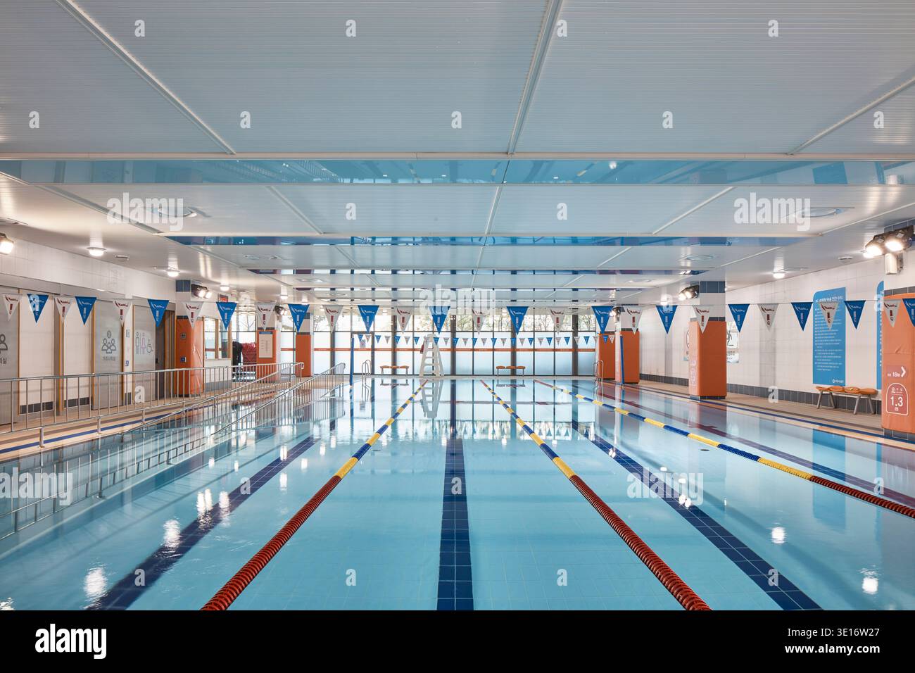 Sala piscina interna con corsie, terrazza e illuminazione luminosa. Foto Stock