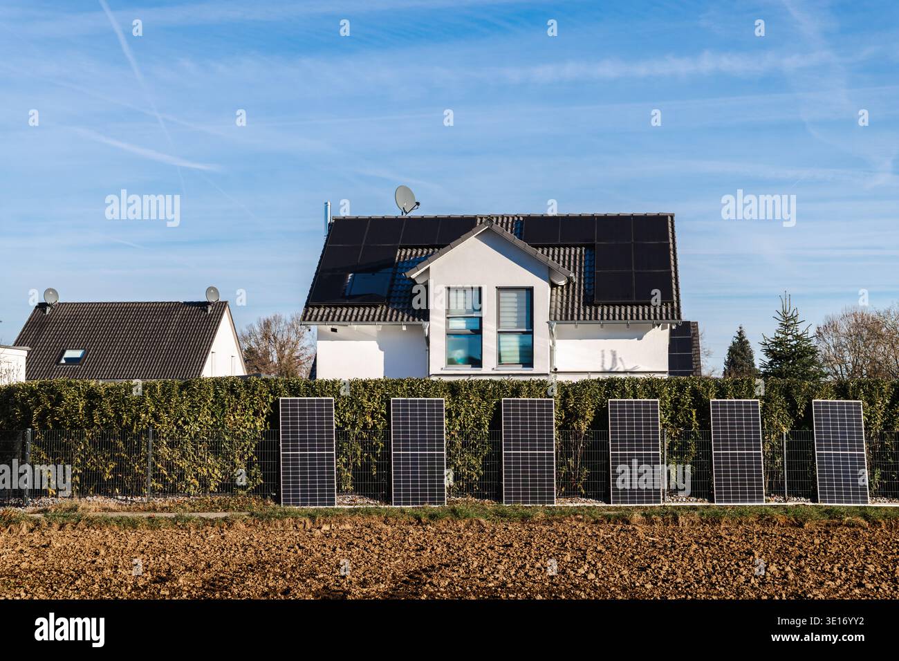 Casa moderna con pannelli solari sul tetto e moduli fotovoltaici installati in una zona residenziale in Germania Foto Stock