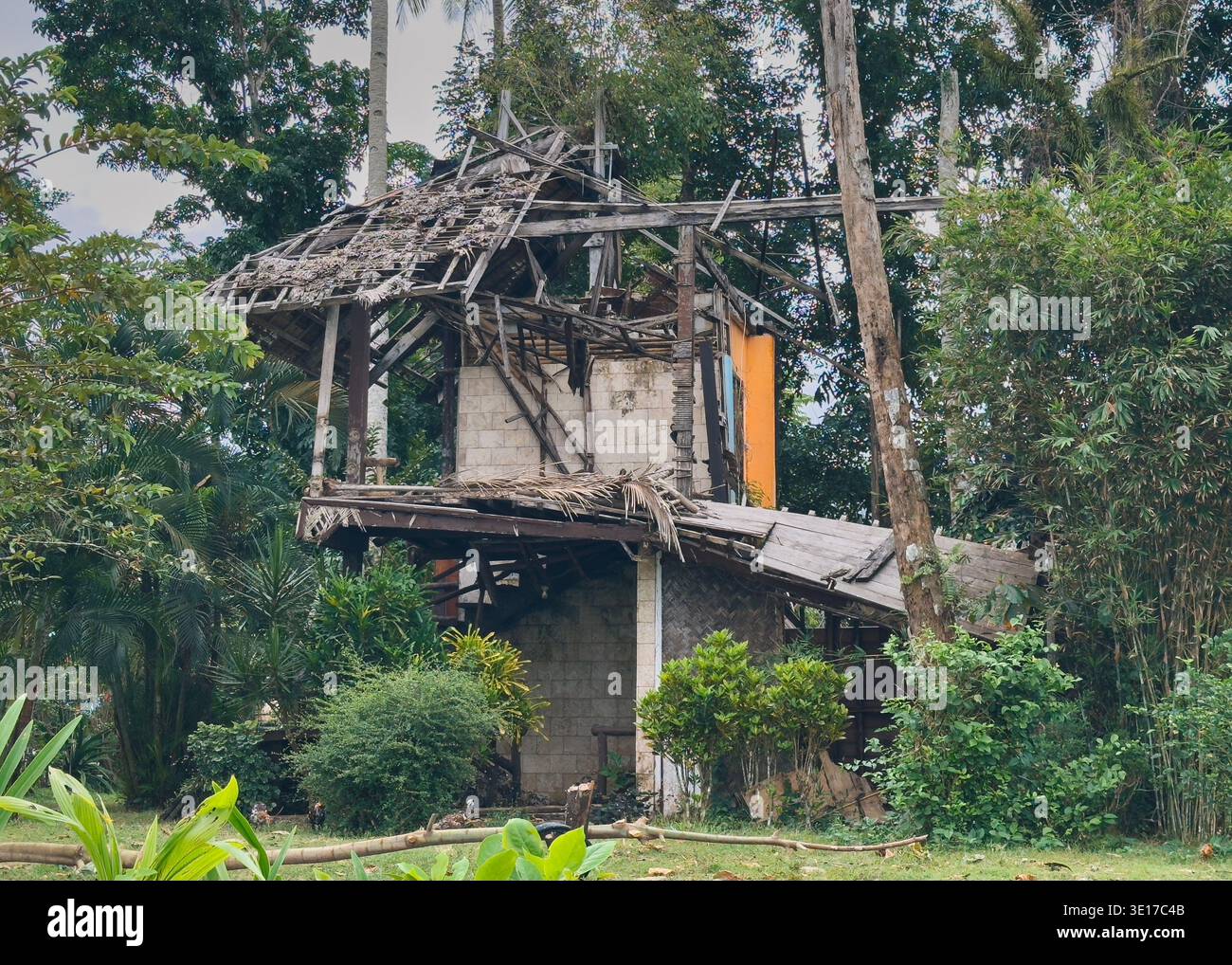 Sistemazione danneggiata da tornado a Port Barton, Palawan, Filippine, che mostra la casa tropicale distrutta circondata da una vegetazione lussureggiante. Foto Stock