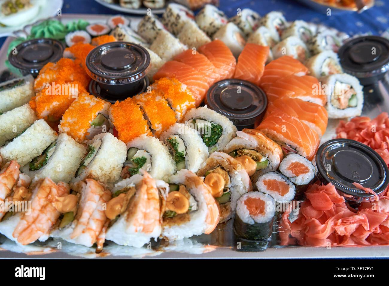 Una vista ravvicinata di un grande piatto di sushi assortito che propone vari tipi di cucina giapponese. La disposizione comprende fette di sashimi di salmone fresco, Foto Stock