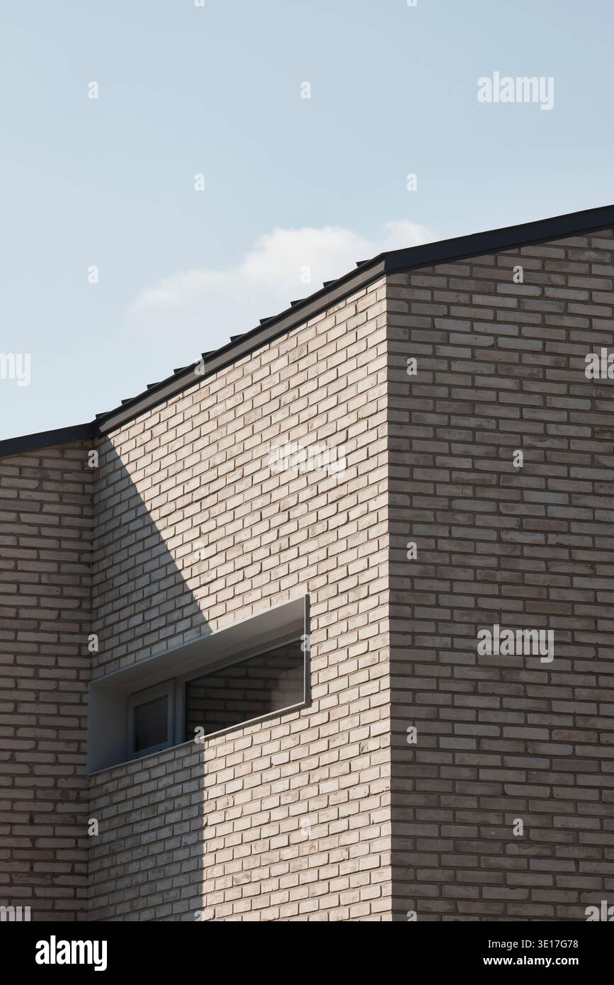 Pareti in mattoni che si aprono in una facciata minimalista e contemporanea. Foto Stock
