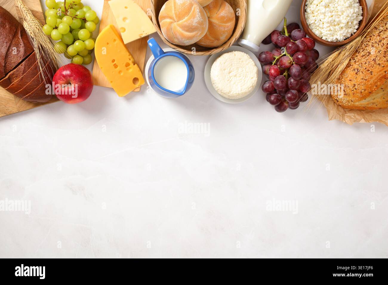 Una selezione di latticini tradizionalmente gustati durante Shavuot, tra cui vari formaggi, latte, pane e frutta. Questa disposizione kosher mette in evidenza il Foto Stock