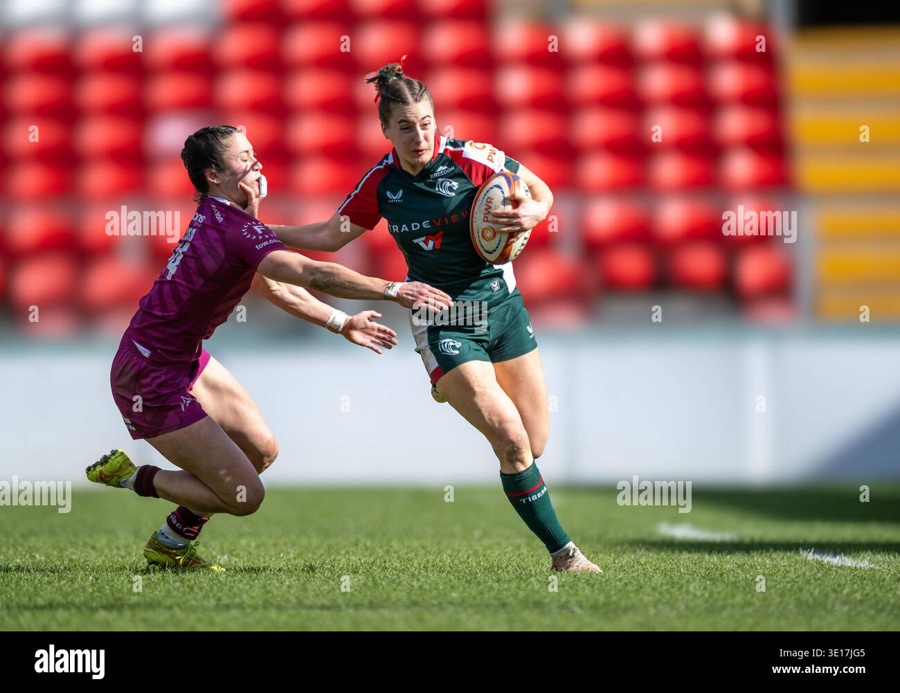 Giocatrice femminile dei Leicester Tigers Karolina Kacirkova (verde) che gioca contro i sale Sharks (viola) nella partita di campionato PWR a Leicestershire. Foto Stock