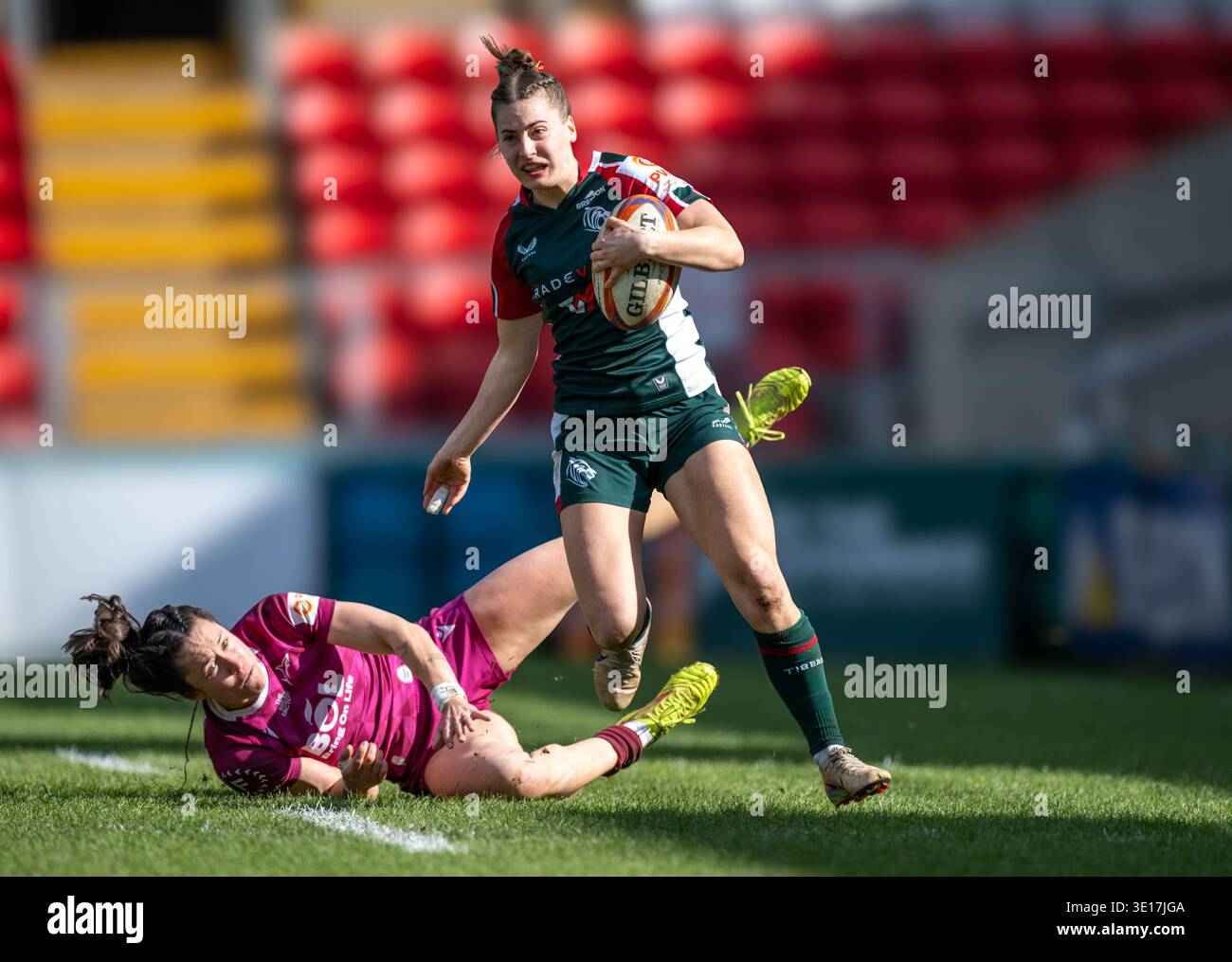 Giocatrice femminile dei Leicester Tigers Karolina Kacirkova (verde) che gioca contro i sale Sharks (viola) nella partita di campionato PWR a Leicestershire. Foto Stock