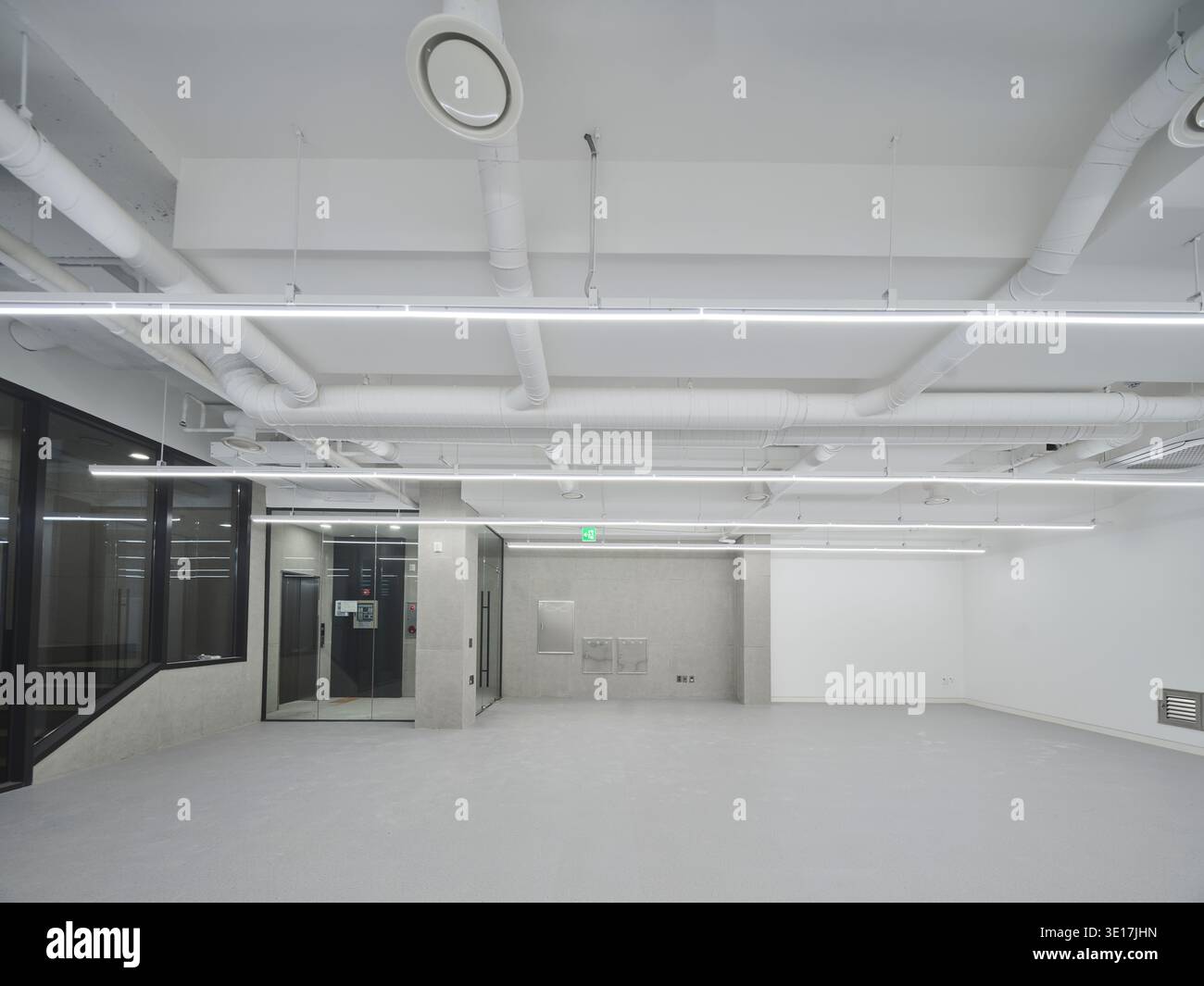 Sala ufficio bianca con servizi a vista e pavimento lucido. Foto Stock