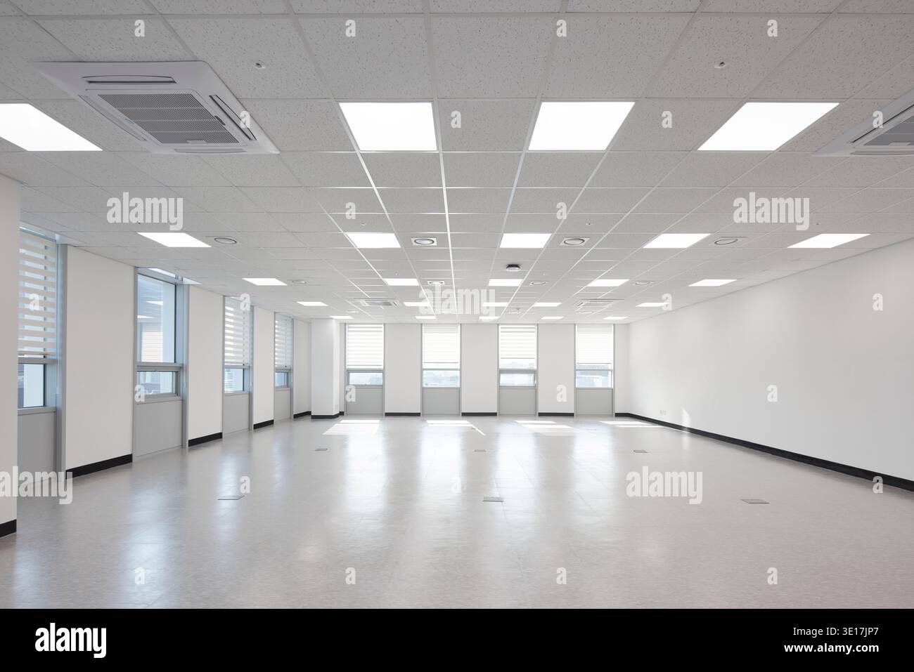 Aula vuota con pareti bianche e illuminazione a strisce. Foto Stock