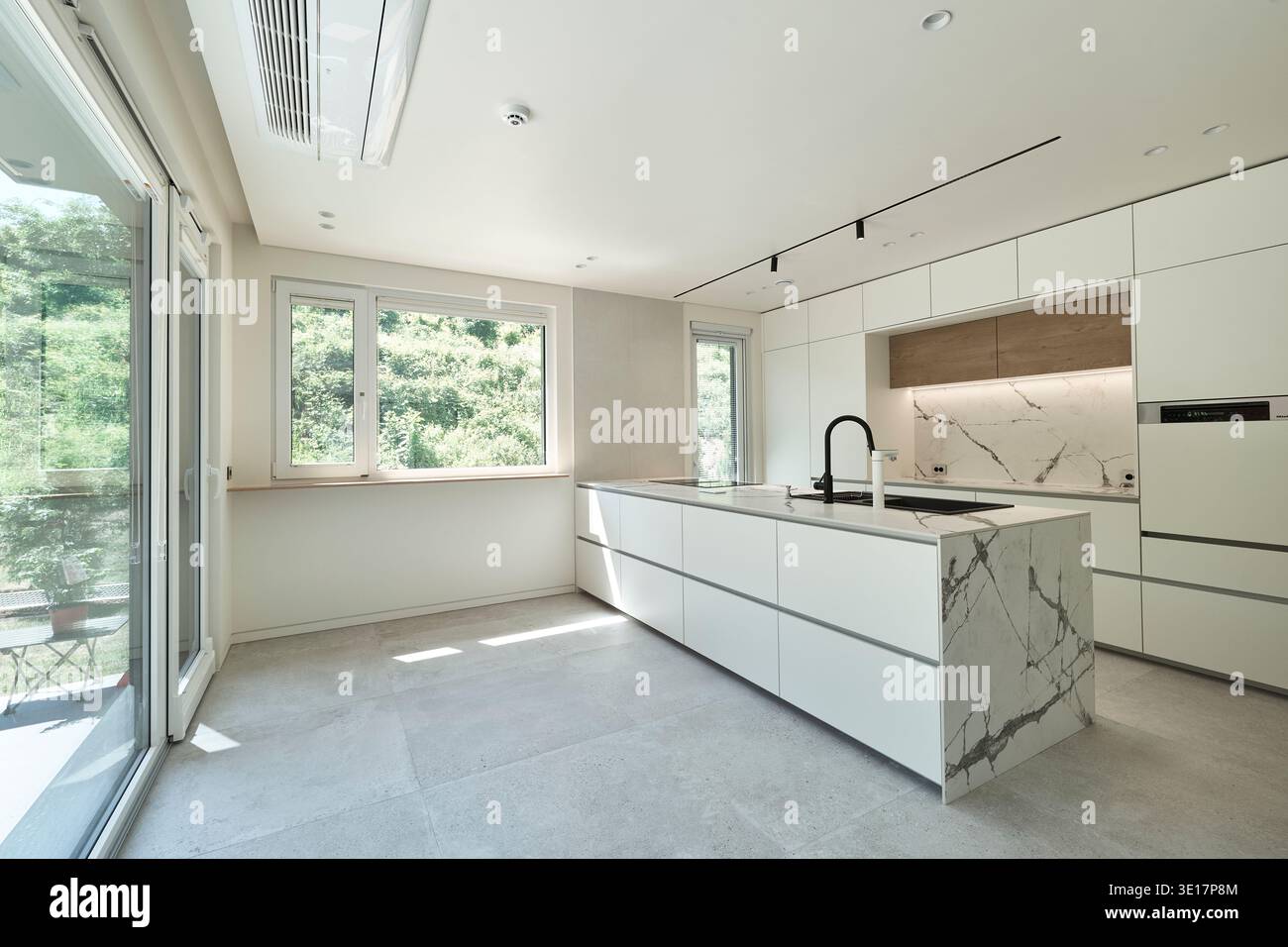 Cucina luminosa con grandi finestre in una casa contemporanea. Foto Stock