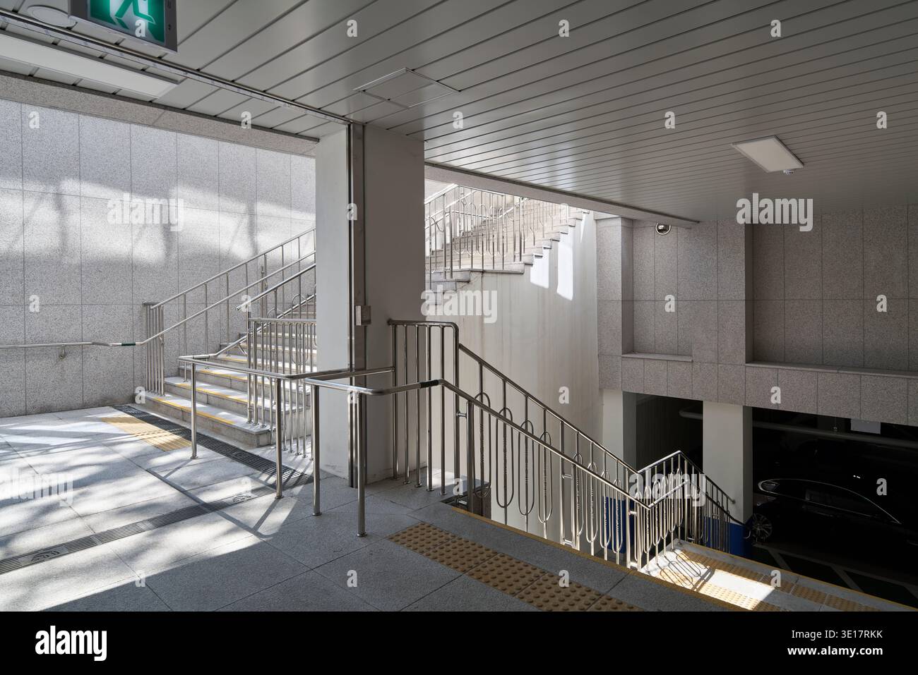 Scala in cemento illuminata dal sole e atterraggio all'interno di un atrio moderno. Foto Stock
