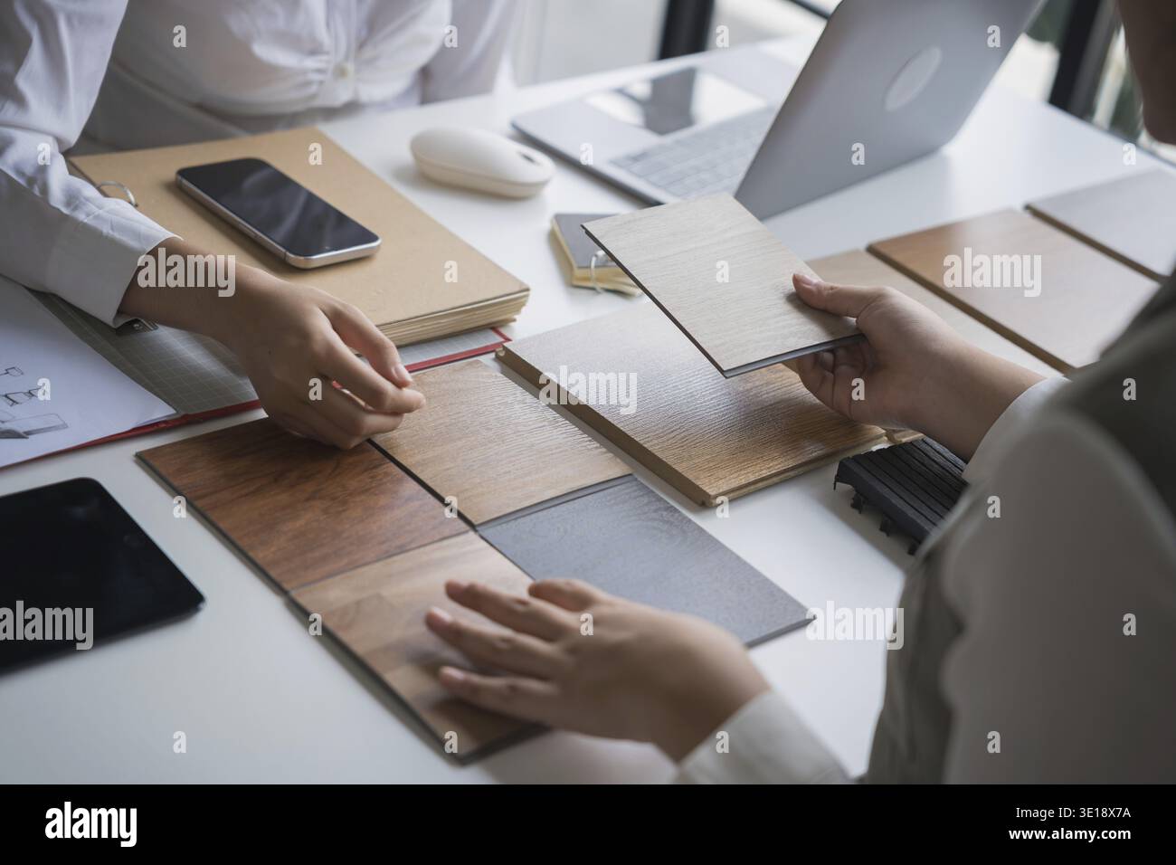 Designer di interni che presenta campioni di materiali in legno ecocompatibili per un arredamento sostenibile Foto Stock