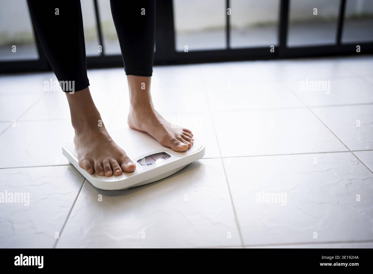 Perdere peso. Dieta grassa e piedini graduati posizionati su bilance elettroniche per il controllo del peso. Strumento di misurazione in chilogrammi per la dieta Foto Stock