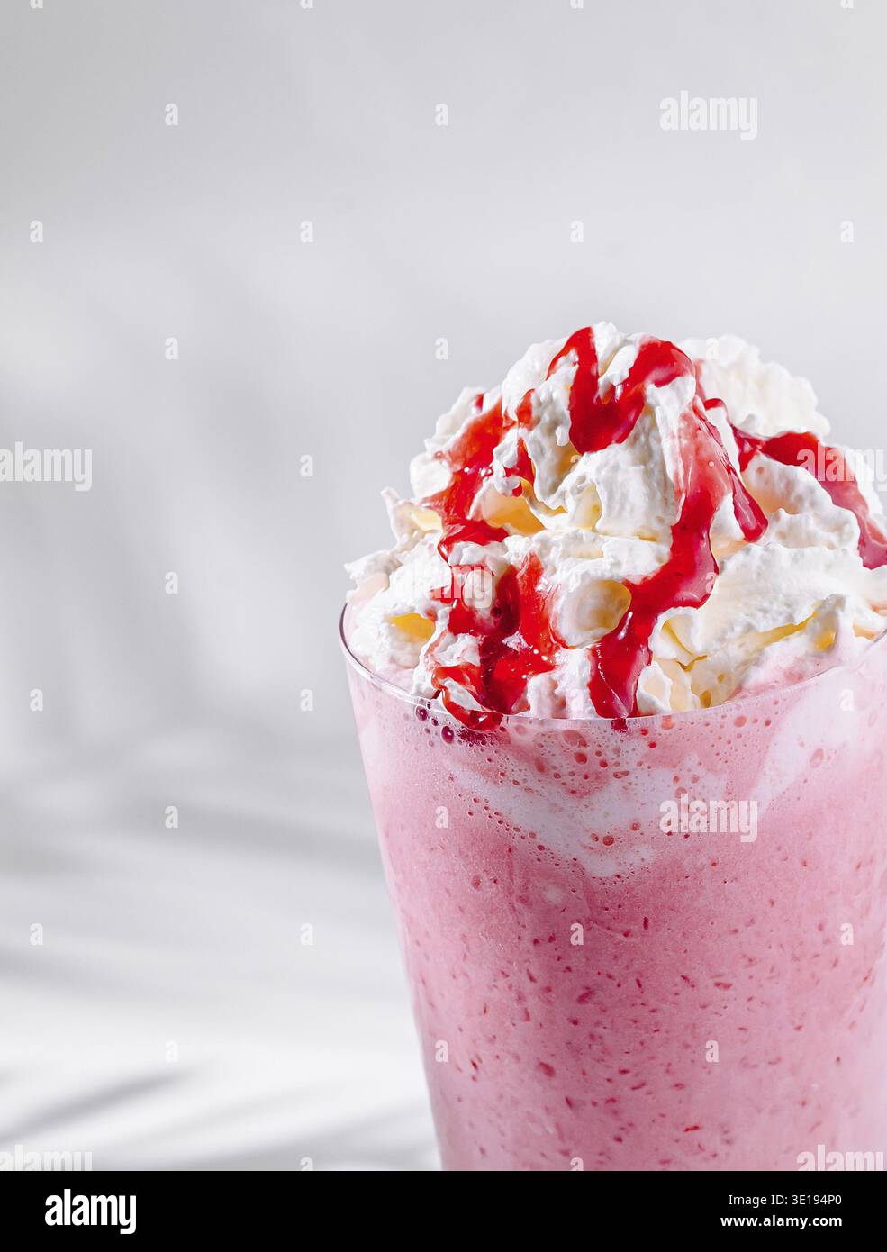 Delizioso frullato di fragole con panna montata e sciroppo Foto Stock