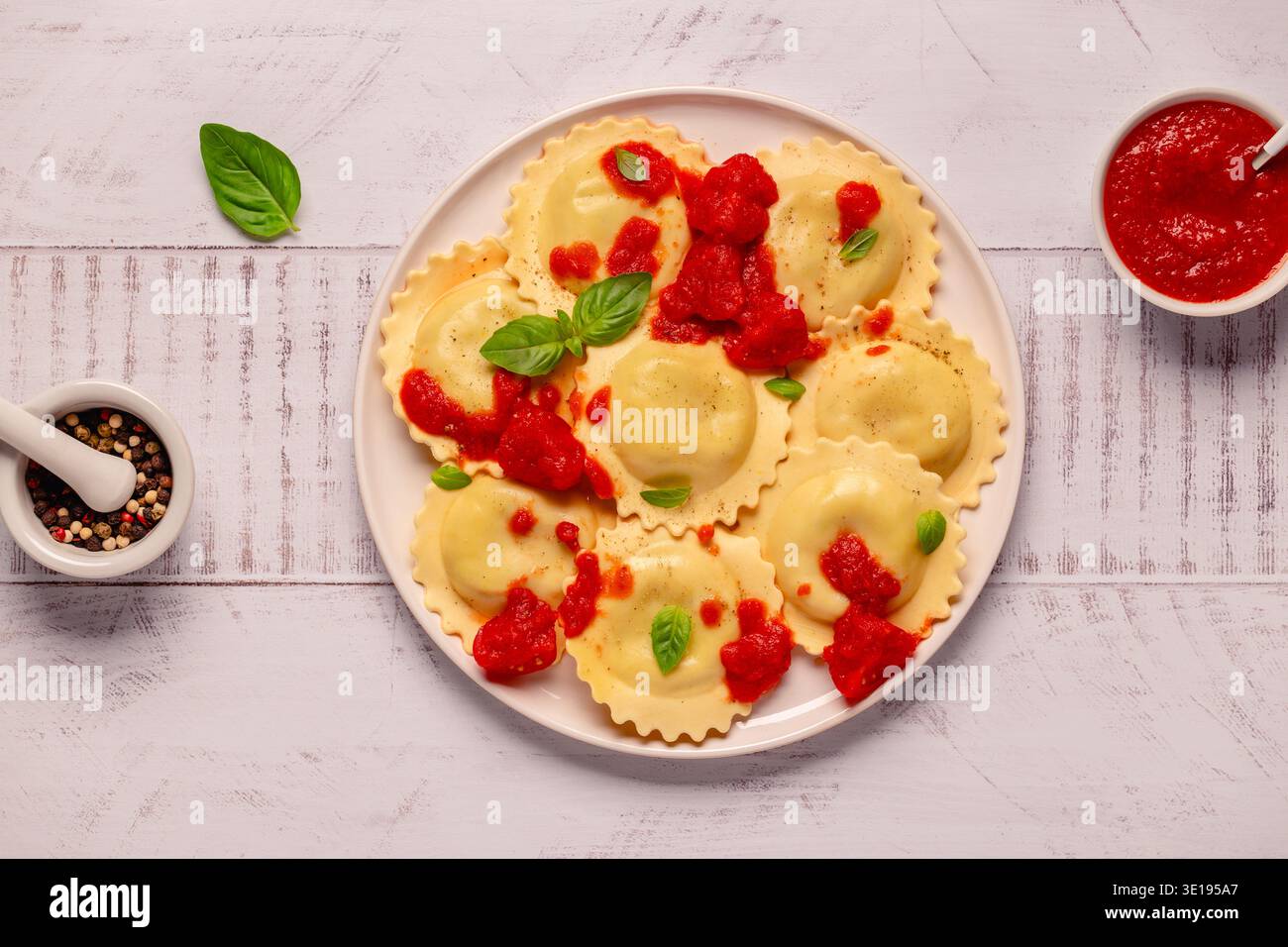 Ravioli con salsa di pomodoro e basilico su piatto bianco. Foto Stock