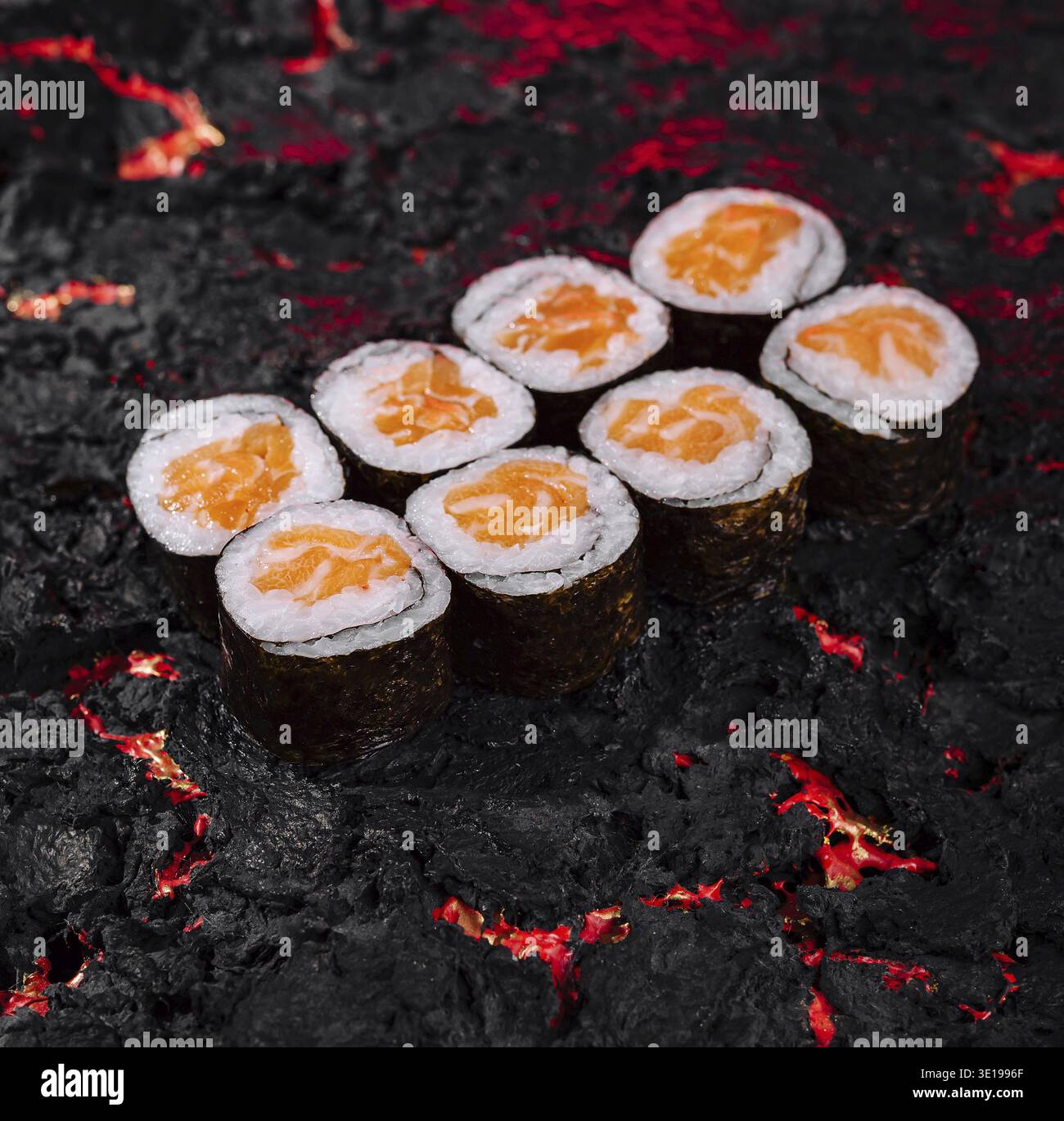 Provate il fuoco e la calda delizia del sushi vulcanico con colori vivaci. Arte culinaria creativa. E cucina creativa con sushi roll. Specialità di pesce Foto Stock