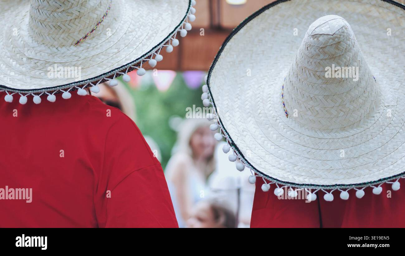 Musicisti Mariachi che indossano sombrero e poncho rosso che si esibiscono ad una festa messicana Foto Stock