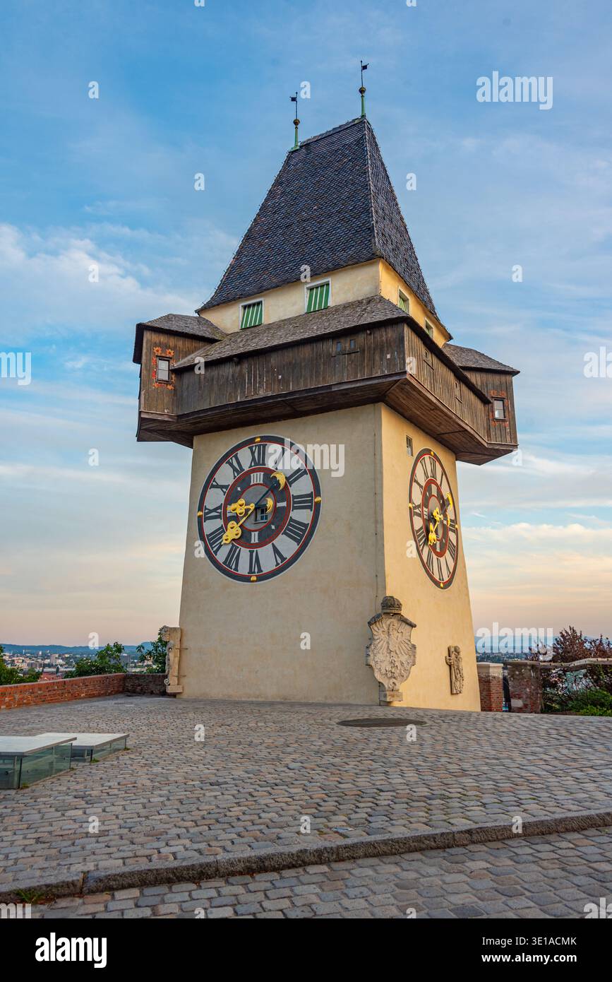 Vista al tramonto della torre dell'orologio nella città austriaca di Graz. IMMAGINE Foto Stock