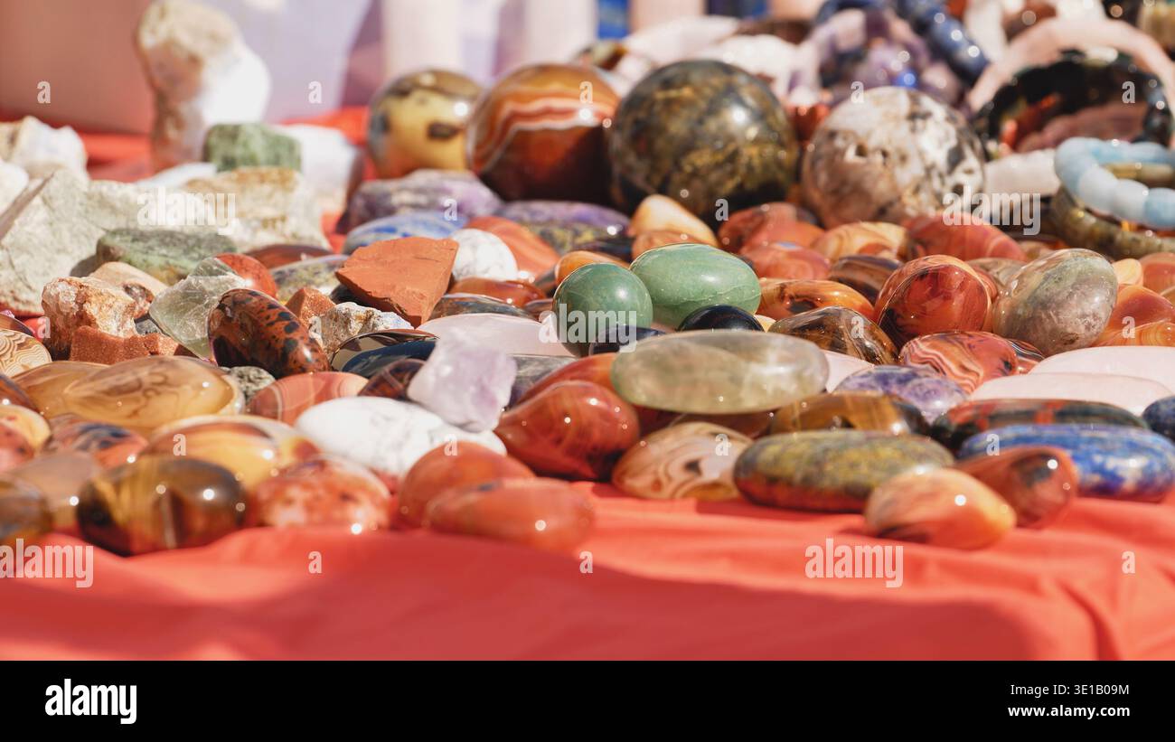 Pietre preziose colorate lucidate e minerali adagiati su un panno rosso Foto Stock