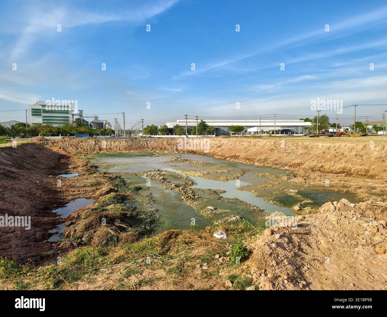 Scavi, con rocce e terreno accumulati, creando acqua stagnante inquinata con alghe verdi o muck, progetti infrastrutturali, Phnom Penh, Cambogia Foto Stock