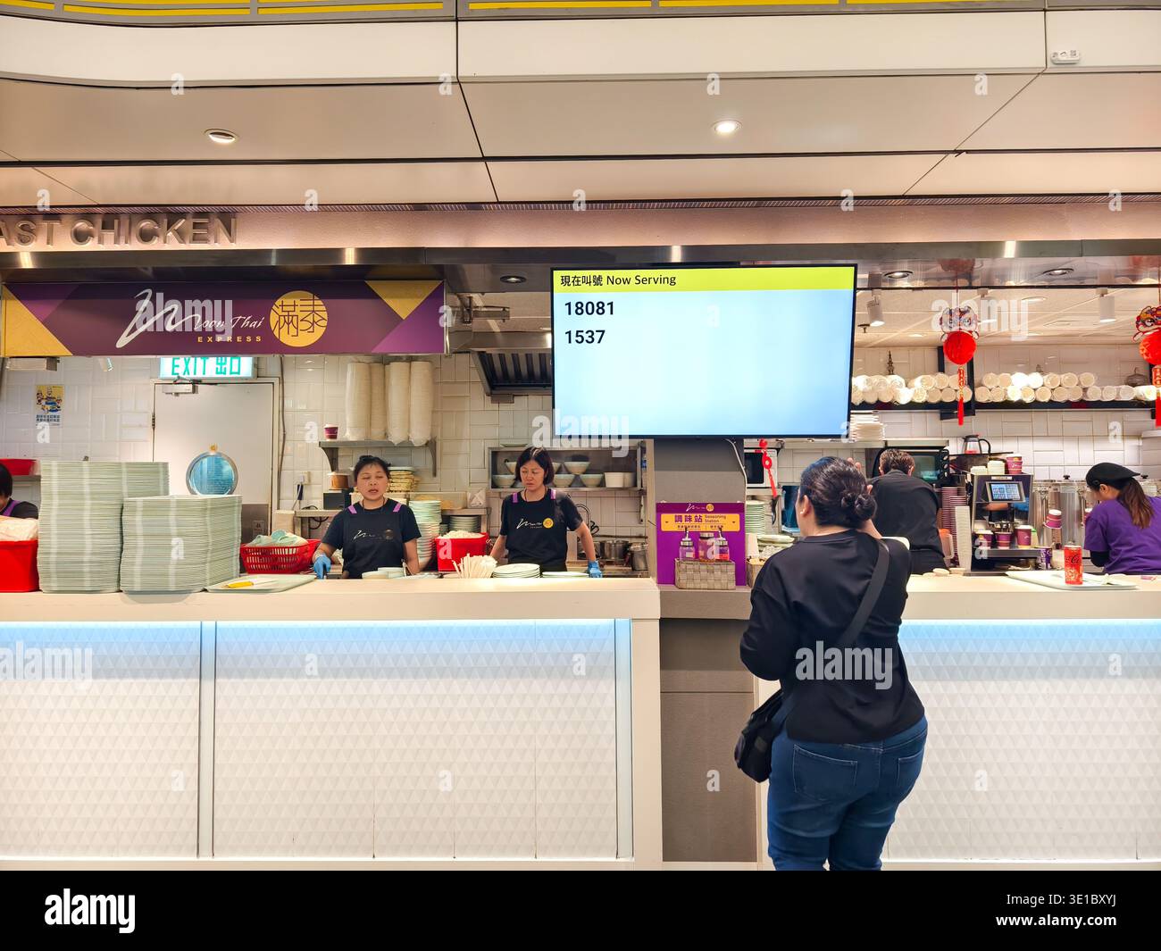 Modello di banco comune nei ristoranti degli aeroporti, schermi digitali che mostrano lo stato e i numeri degli ordini, Moon Thai Express Cafe, aeroporto di Hong Kong Foto Stock