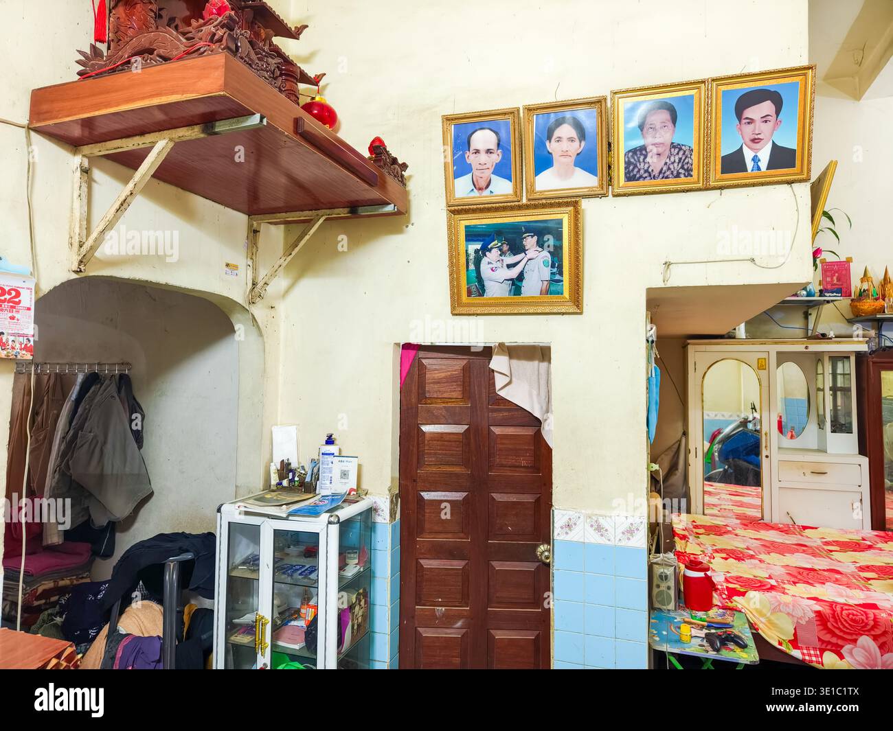Kampong Cham, Cambogia, Asia, casa residenziale, ritratti incorniciati di familiari disposti sul muro, altare posizionato in alto sul muro, Foto Stock
