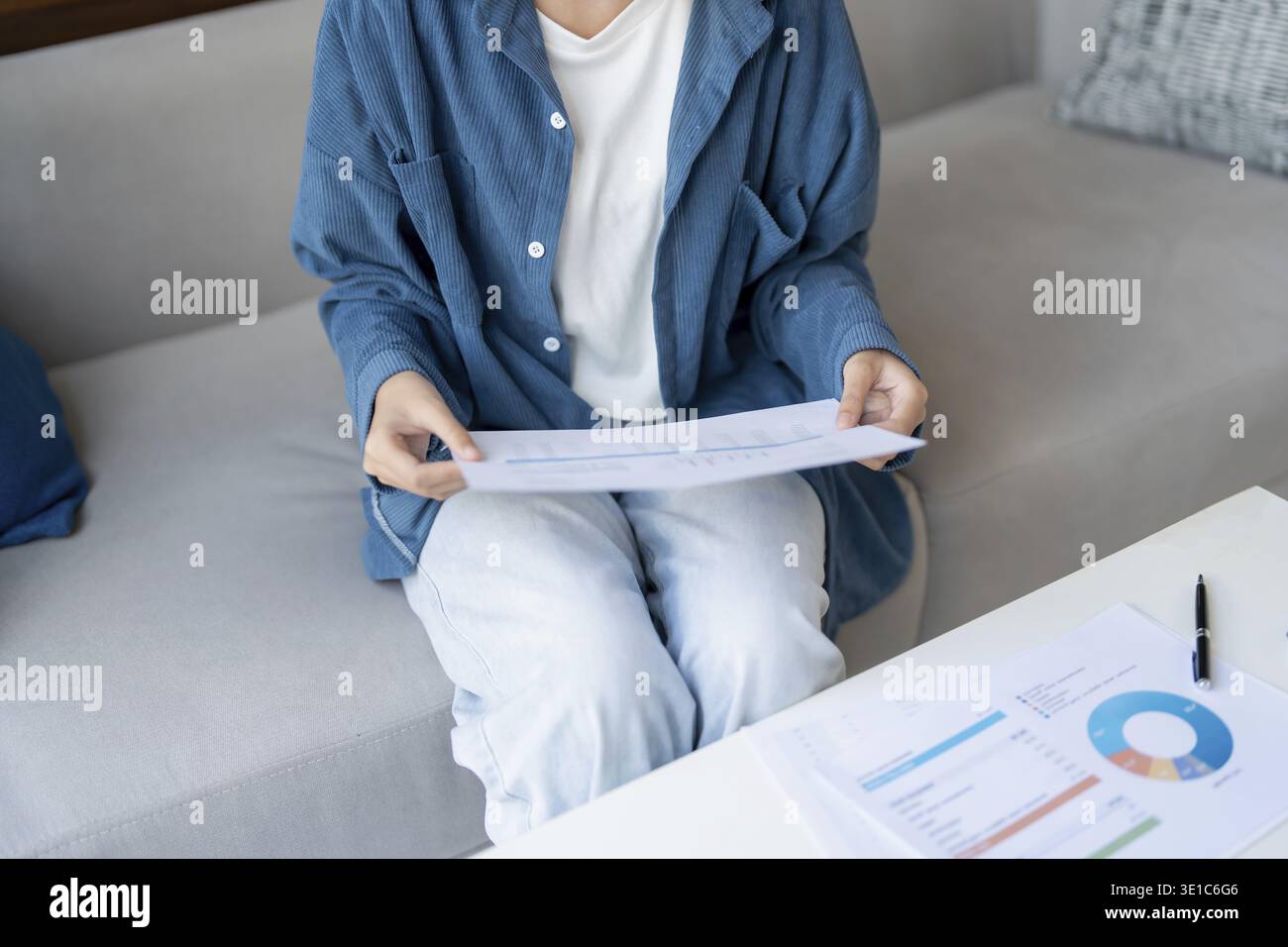 Donna asiatica che gestisce le finanze paga le bollette e budget finanziario a casa Foto Stock
