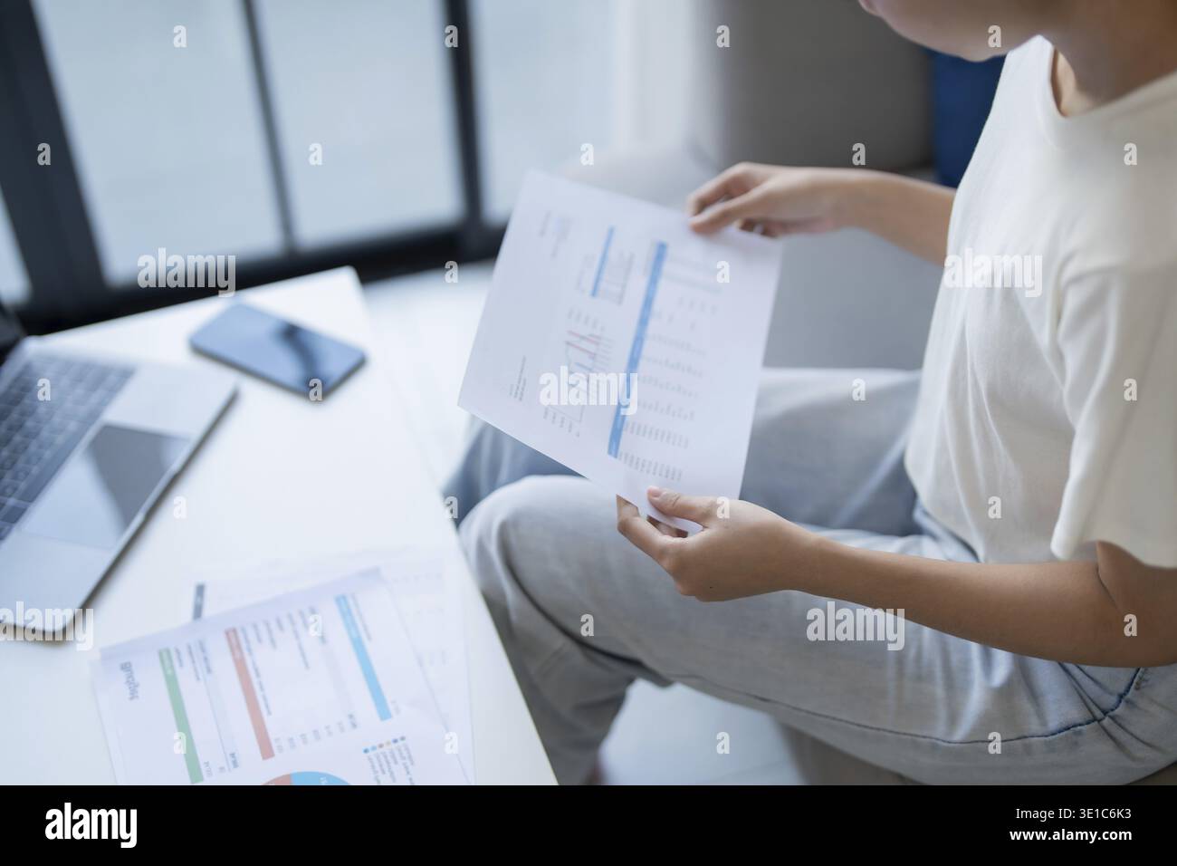 Donna asiatica che gestisce le finanze paga le bollette e budget finanziario a casa Foto Stock