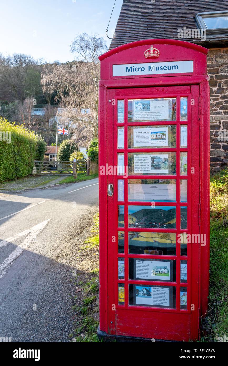 Tradizionale telefono rosso britannico utilizzato come micro museo con la bandiera Union Jack sullo sfondo nella città mercato di Church Stretton. Foto Stock