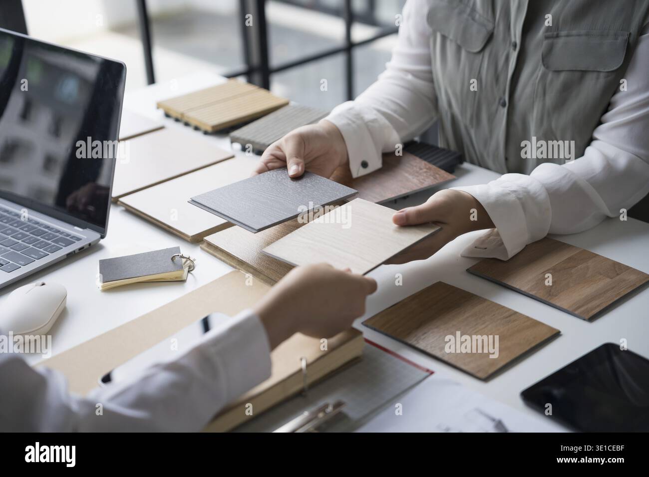 Designer di interni che presenta campioni di materiali in legno ecocompatibili per un arredamento sostenibile Foto Stock