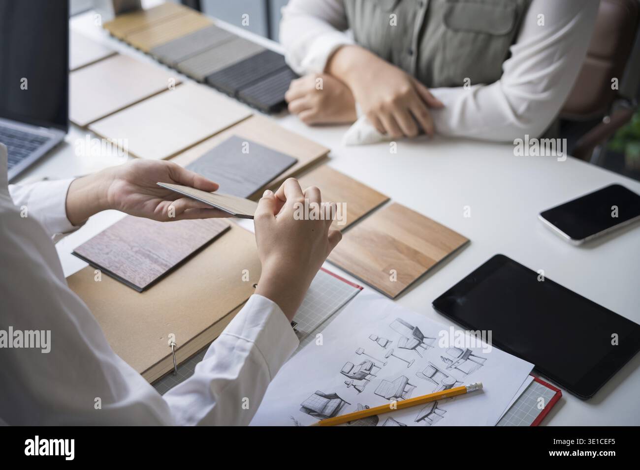 Designer di interni che presenta campioni di materiali in legno ecocompatibili per un arredamento sostenibile Foto Stock